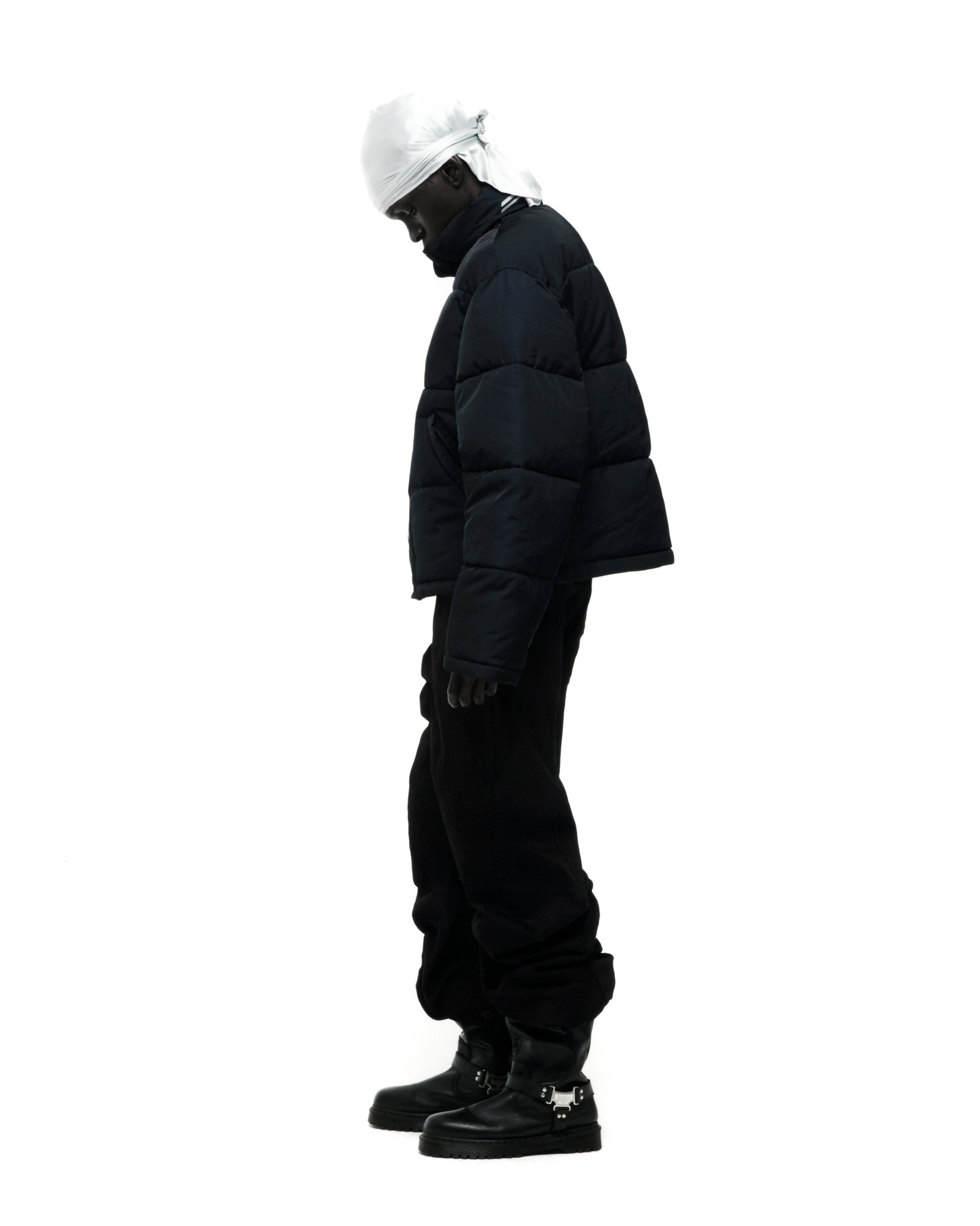 Black TRACKHAWK poly-fill puffer jacket with reflective text, side pockets, and adjustable hem.