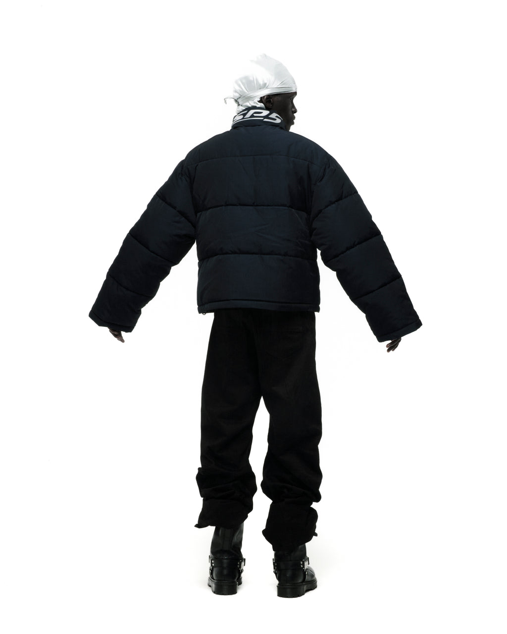 Black TRACKHAWK puffer jacket with reflective text, worn by a person facing away.