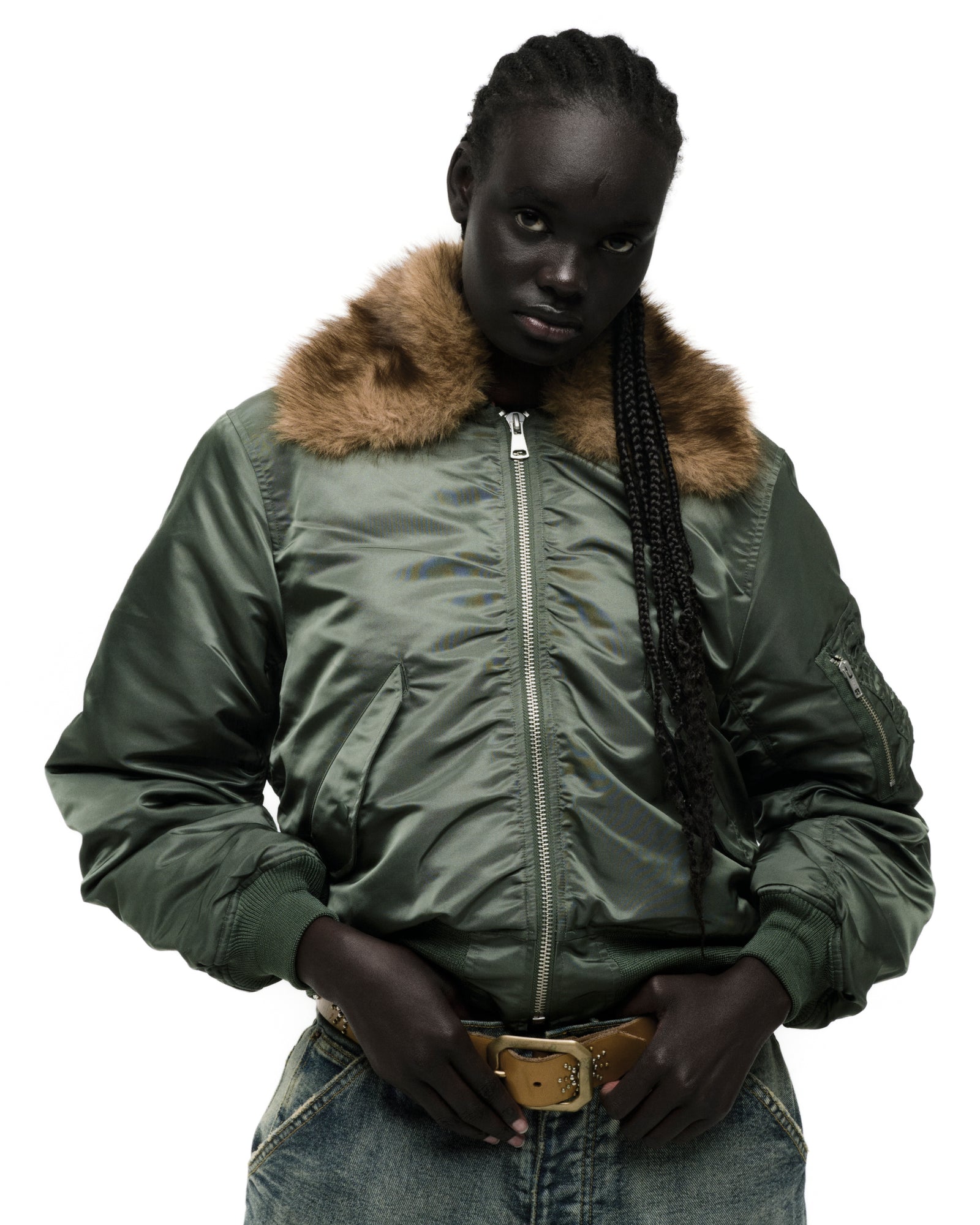Green nylon bomber jacket with a brown faux fur collar, worn by a model.