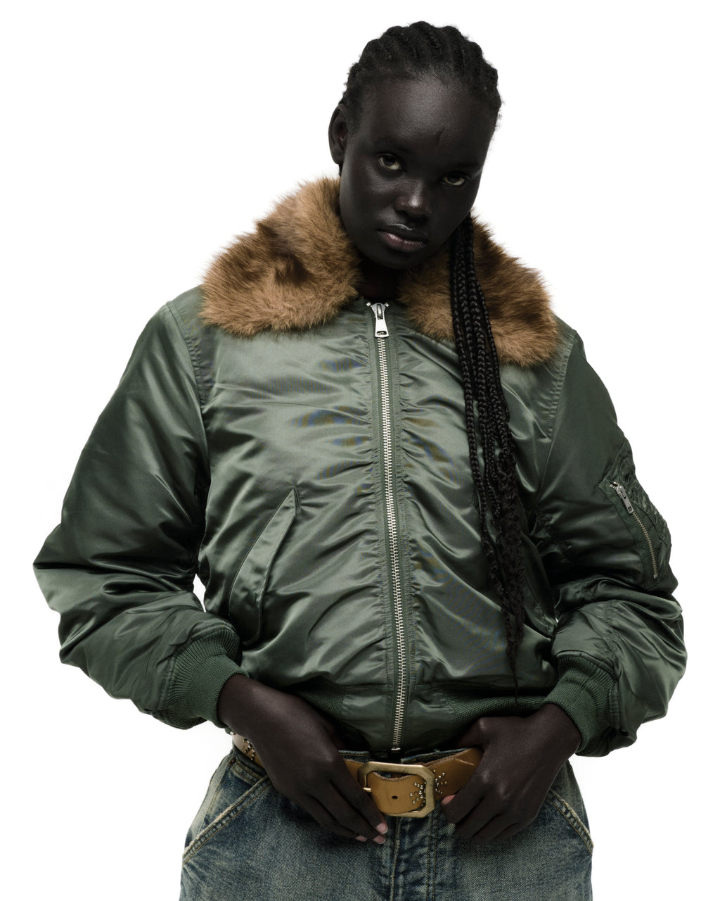 Green nylon bomber jacket with a brown faux fur collar, worn by a model.