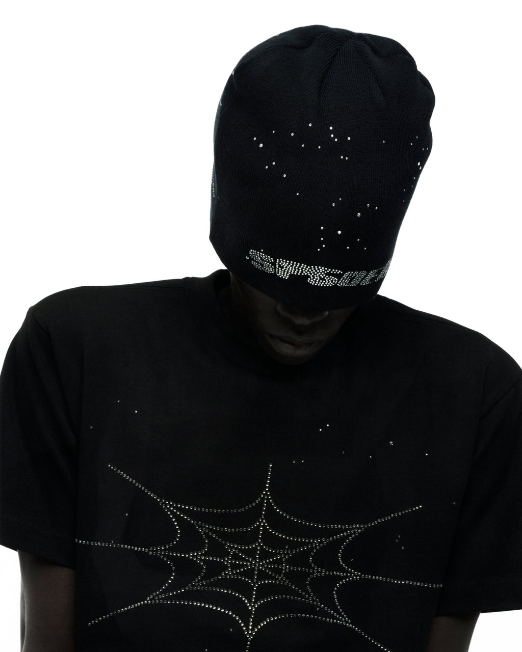 Black cotton tee with rhinestone spiderweb graphic, worn by a person in a matching rhinestone beanie.