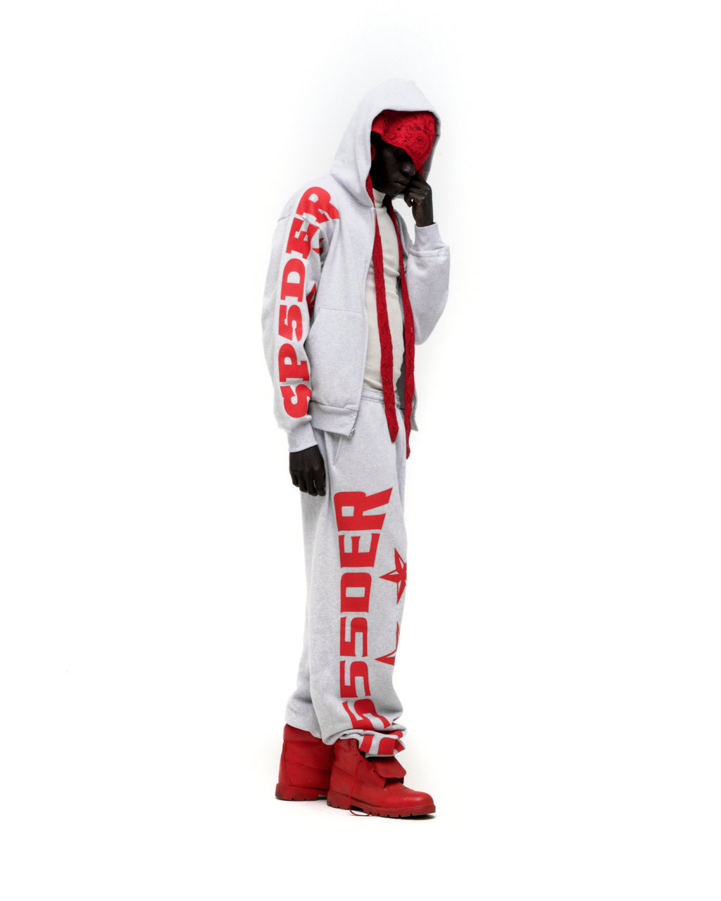 Light grey MX555 zip hoodie and sweatpants with bold red SP5DER text and star print, worn by a person with a red bandana and boots.