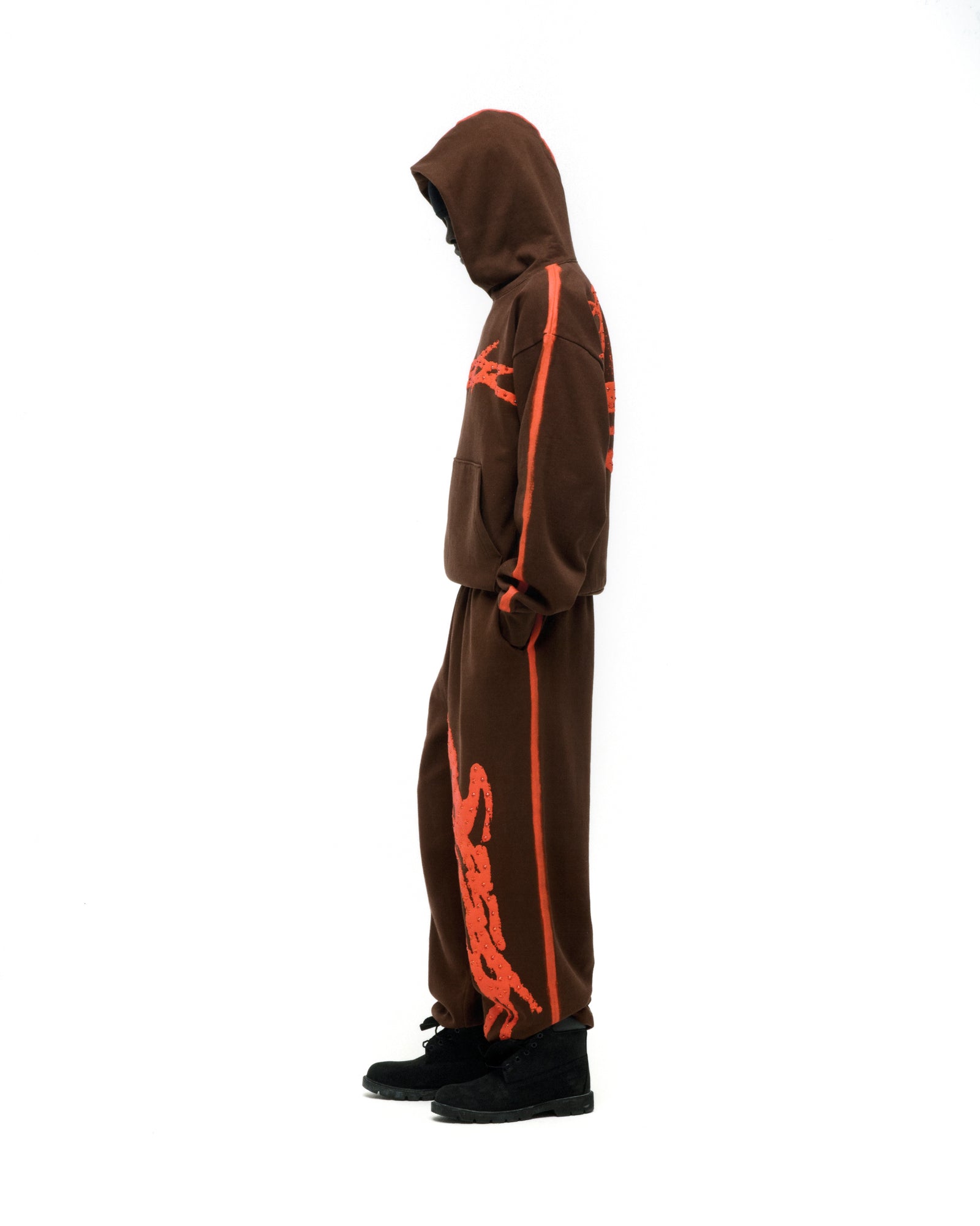 Brown 13oz cotton fleece hoodie and sweatpants with orange sprayed stripes, "SP5DER" logo, and flaming "5" design.