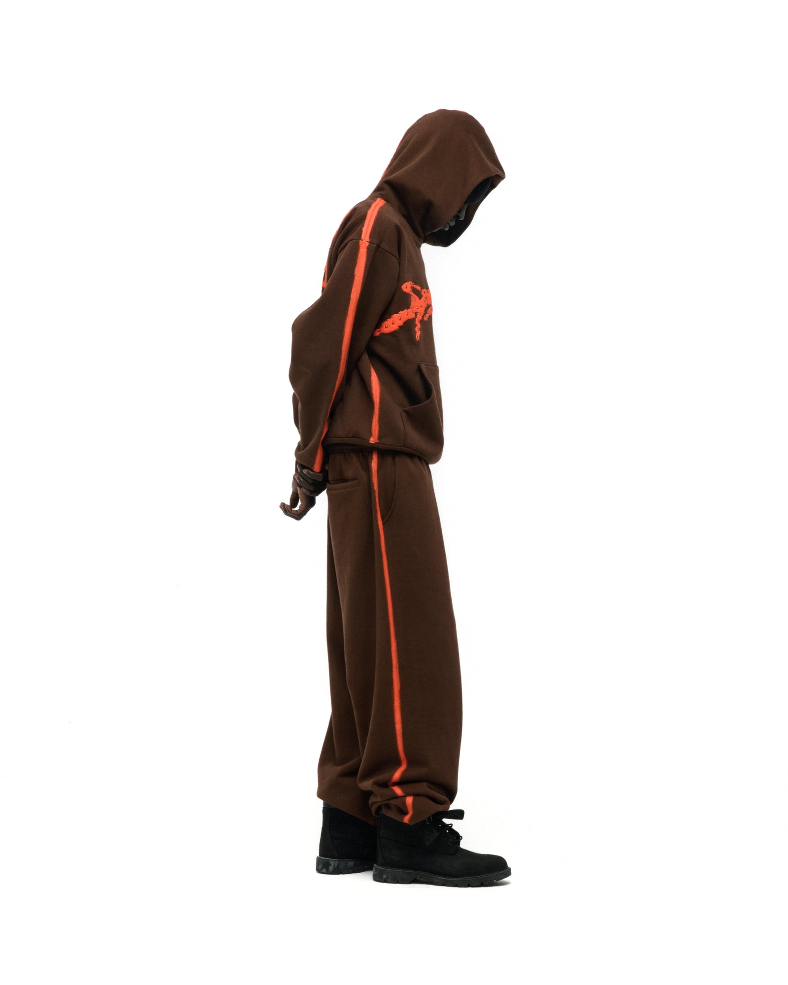 Brown cotton fleece hoodie and sweatpants with orange sprayed-effect stripes and rhinestone "SP5DER" logo.