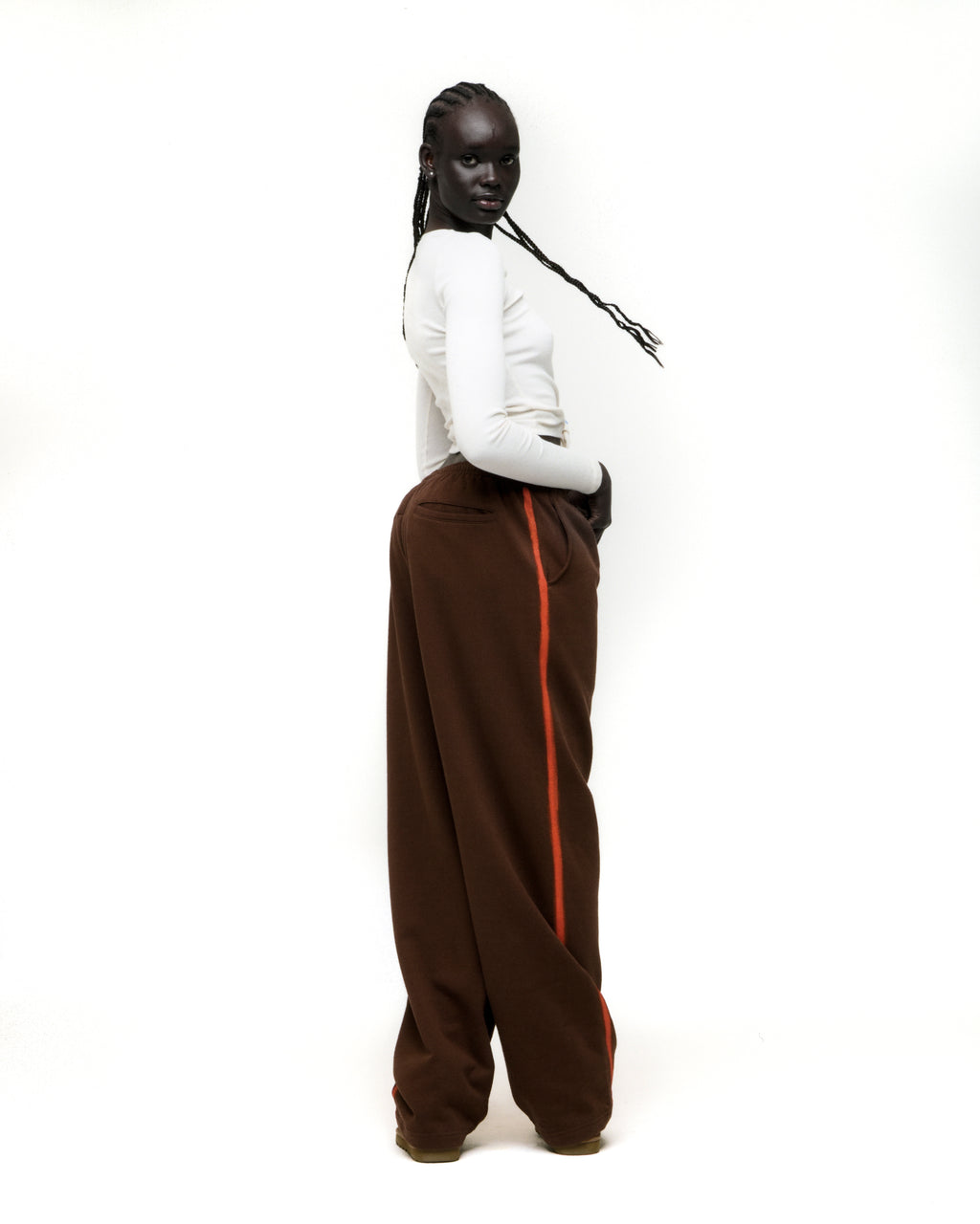Brown wide-leg cotton fleece sweatpants with orange sprayed-effect side stripe.