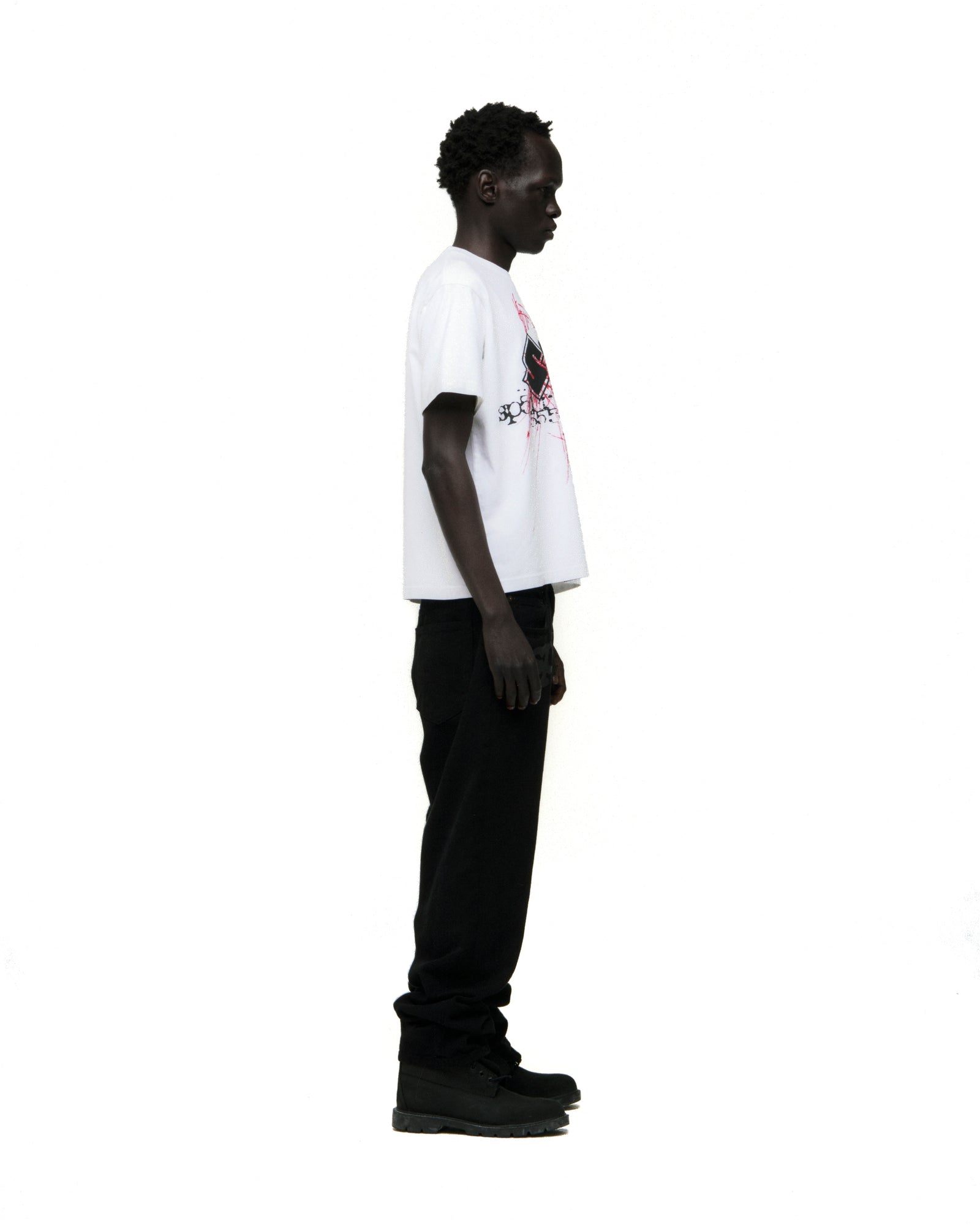 White cotton Vivienne Tee with red graphic print, worn by a model in black pants.