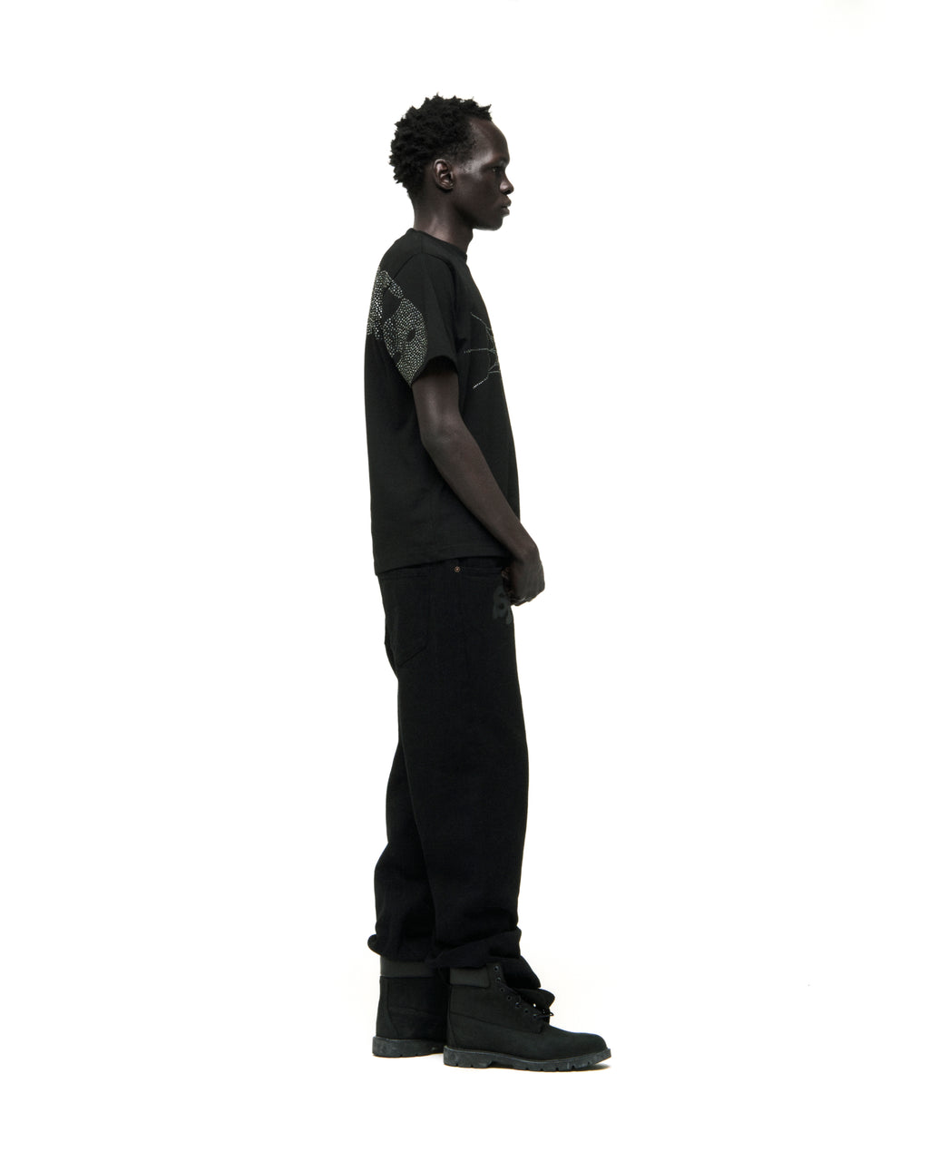 Black cotton tee with rhinestone graphic, worn by a man in profile.