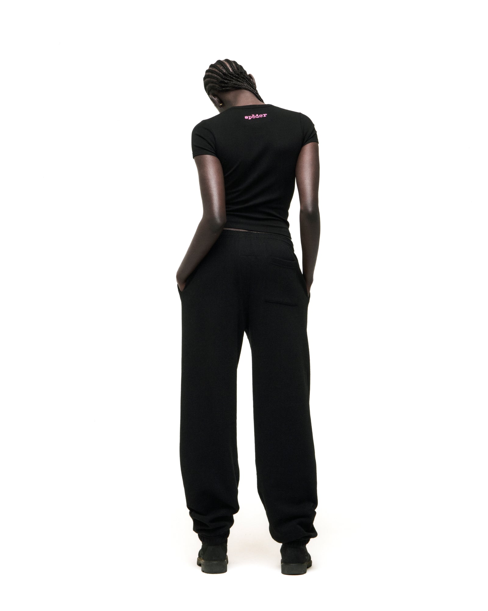 Black cotton/spandex cropped tee with pink 'SP5DER' logo on back neck, worn by a model.
