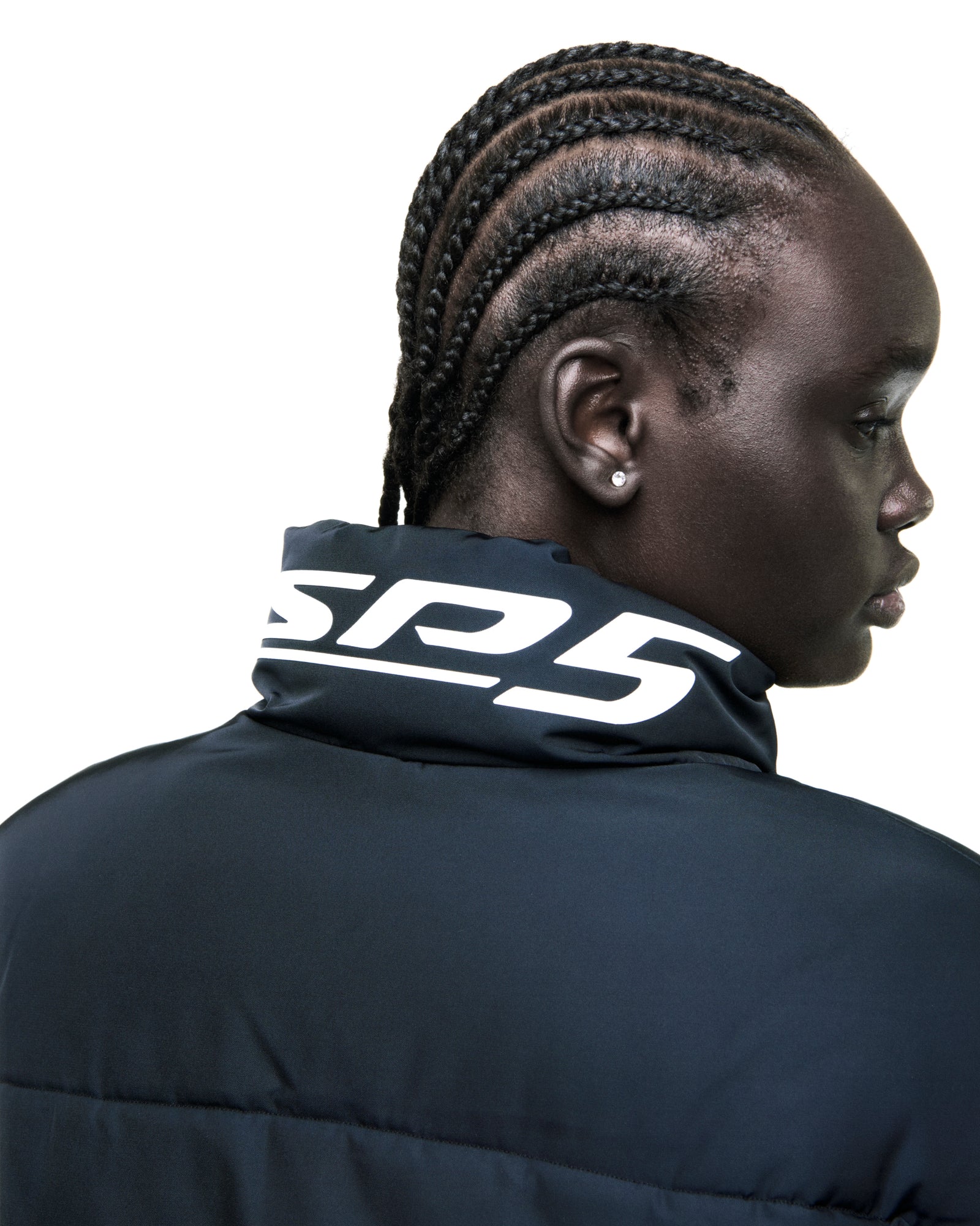 Black poly-fill TRACKHAWK puffer jacket with reflective rubberized text graphic on collar.