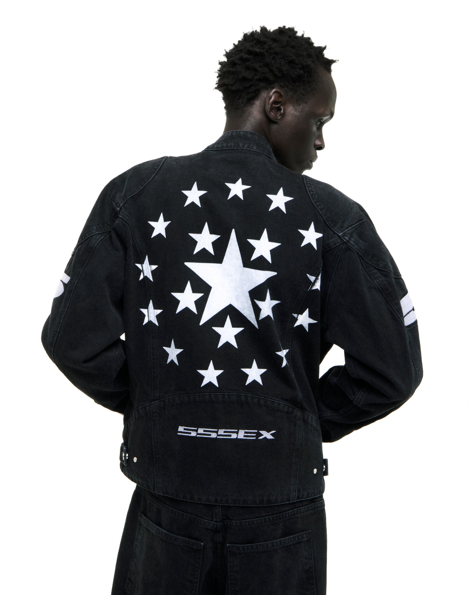 Faded black denim jacket with large white star on back surrounded by smaller stars and "SSSEX" embroidery.