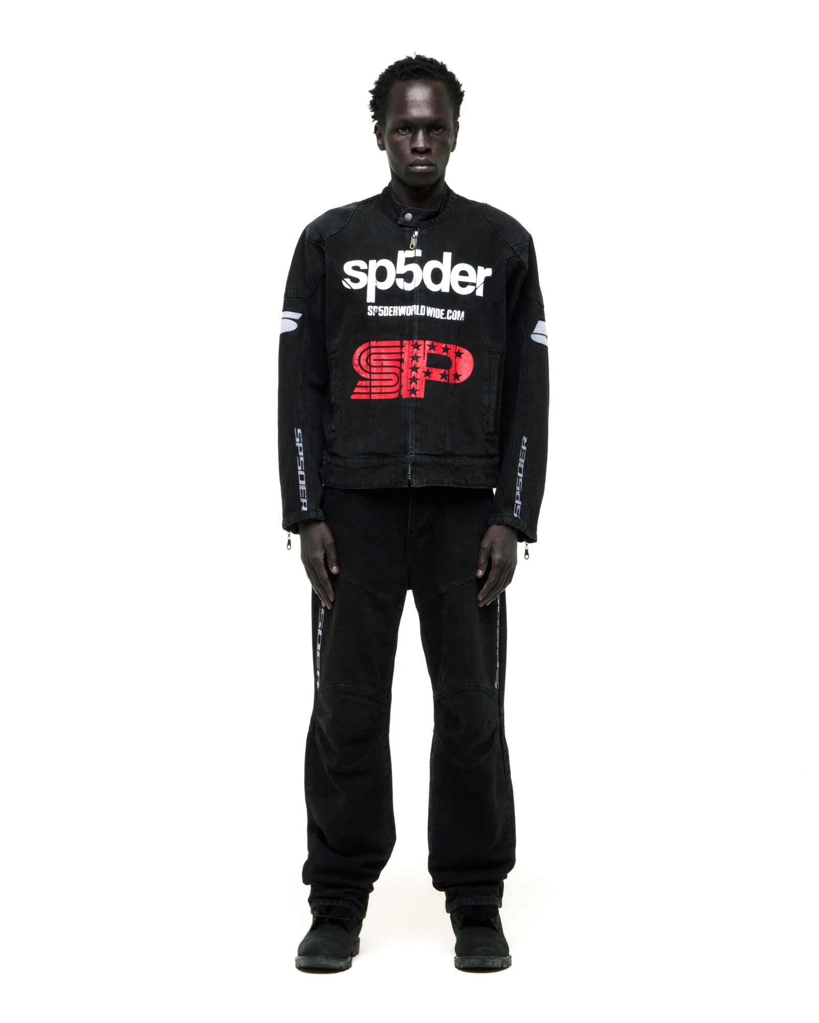Faded black denim jacket with SP5DER print, star graphic, shoulder panels, and zip closure.