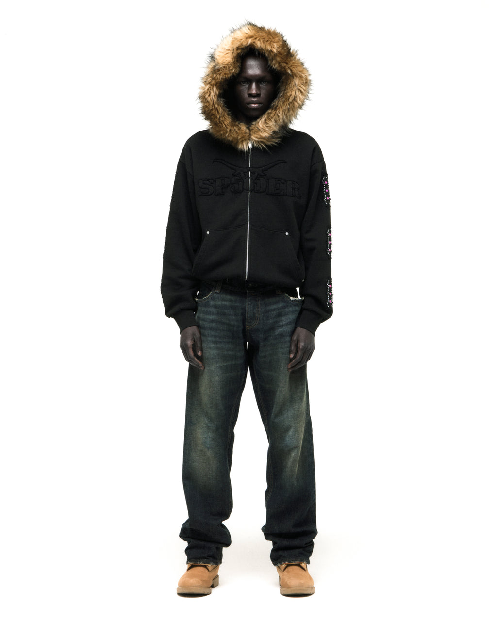 Black 13oz cotton fleece Garibaldi zip-up hoodie with faux fur hood trim, SP5DER text patches, patterned sleeve accents, and studded pockets.