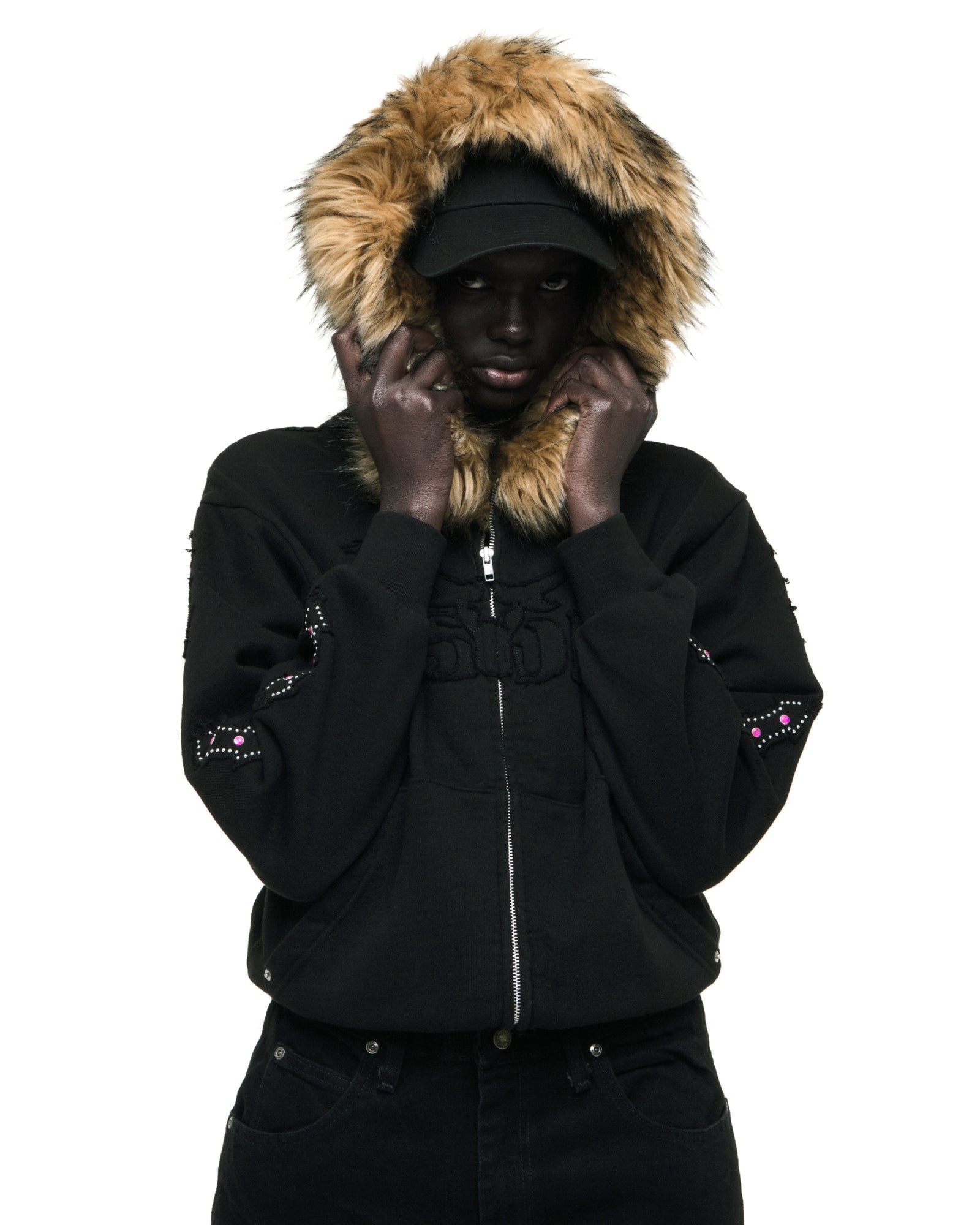 Black 13oz cotton fleece Garibaldi zip-up with faux fur hood trim, SP5DER text patches, patterned sleeves with stone appliqué, and studded pockets.