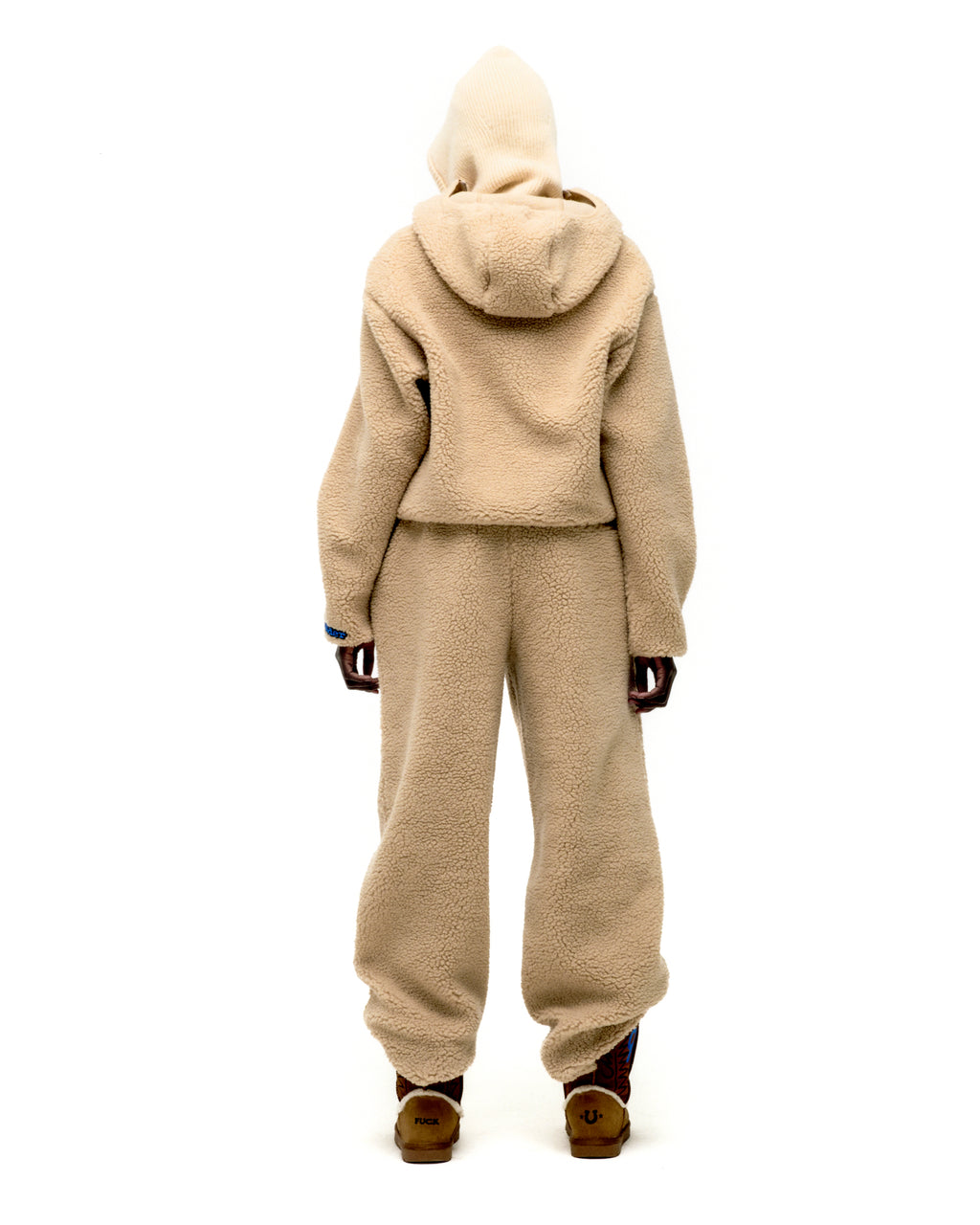 Back view of a person wearing a beige teddy fleece zip-up jacket and matching pants.