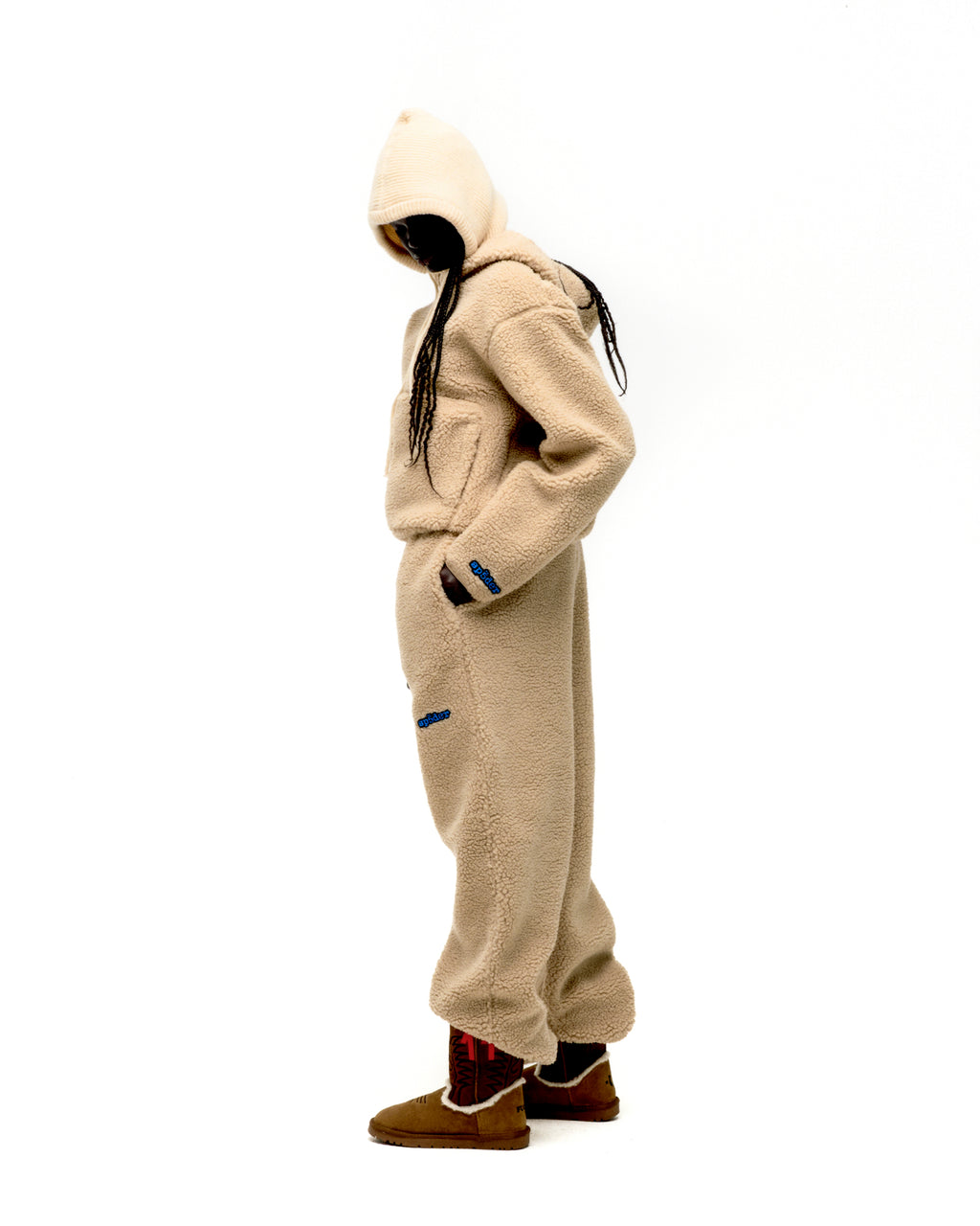 Beige sherpa fleece hooded jacket and matching sweatpants with blue logo patches.