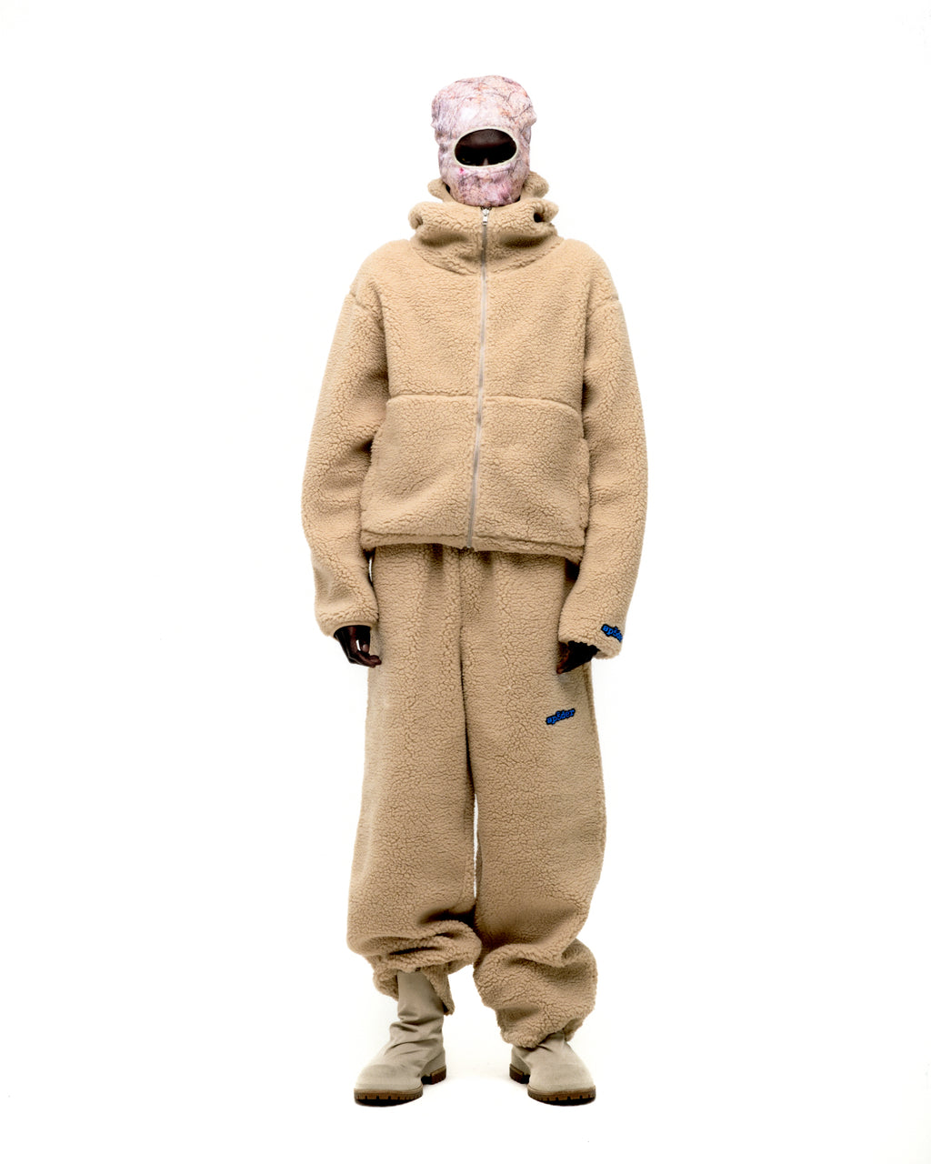 Beige sherpa fleece hooded zip-up jacket and matching sweatpants with blue logo patches.