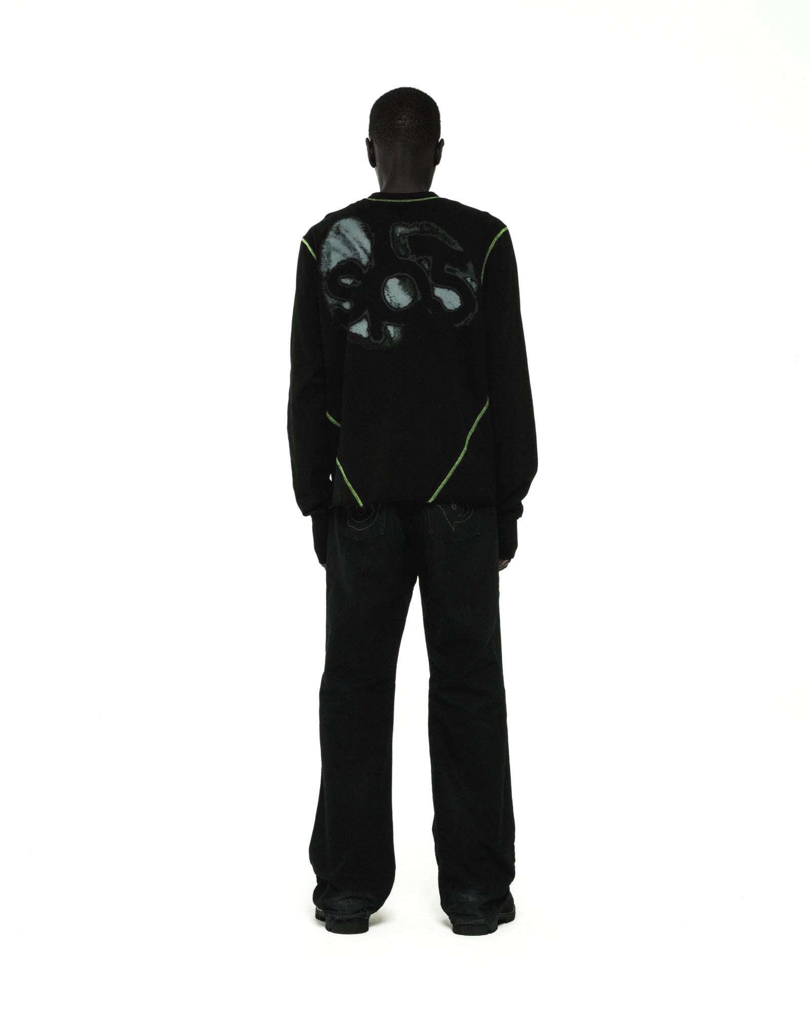 Black cotton long sleeve tee with green contrast stitching and graphic print on back.