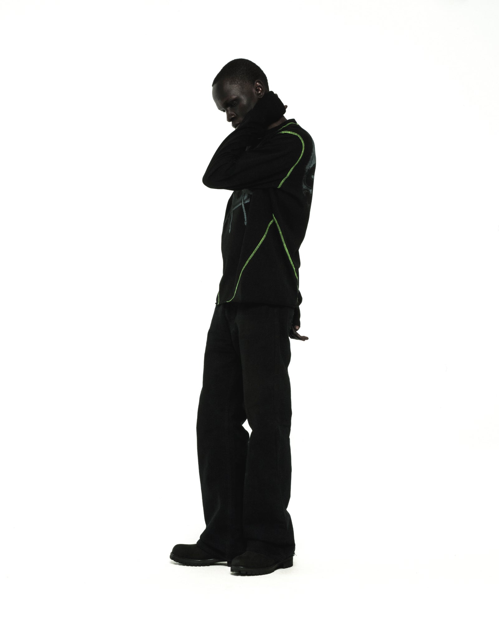 Black cotton long sleeve tee with green contrast stitching and graphic print, worn by a model.