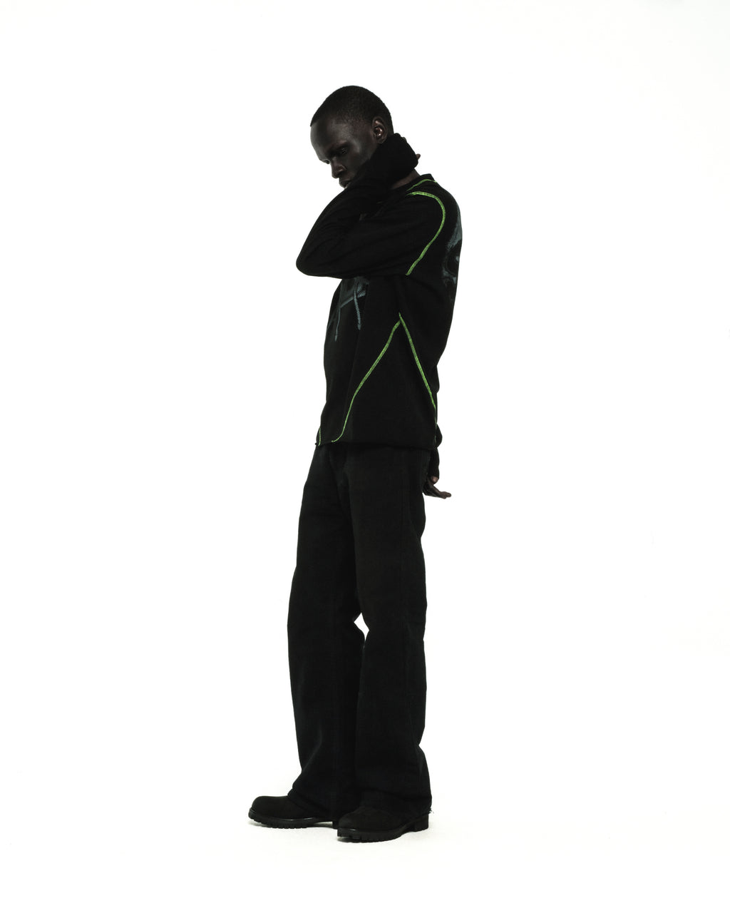 Black cotton long sleeve tee with green contrast stitching and graphic print, worn by a model.