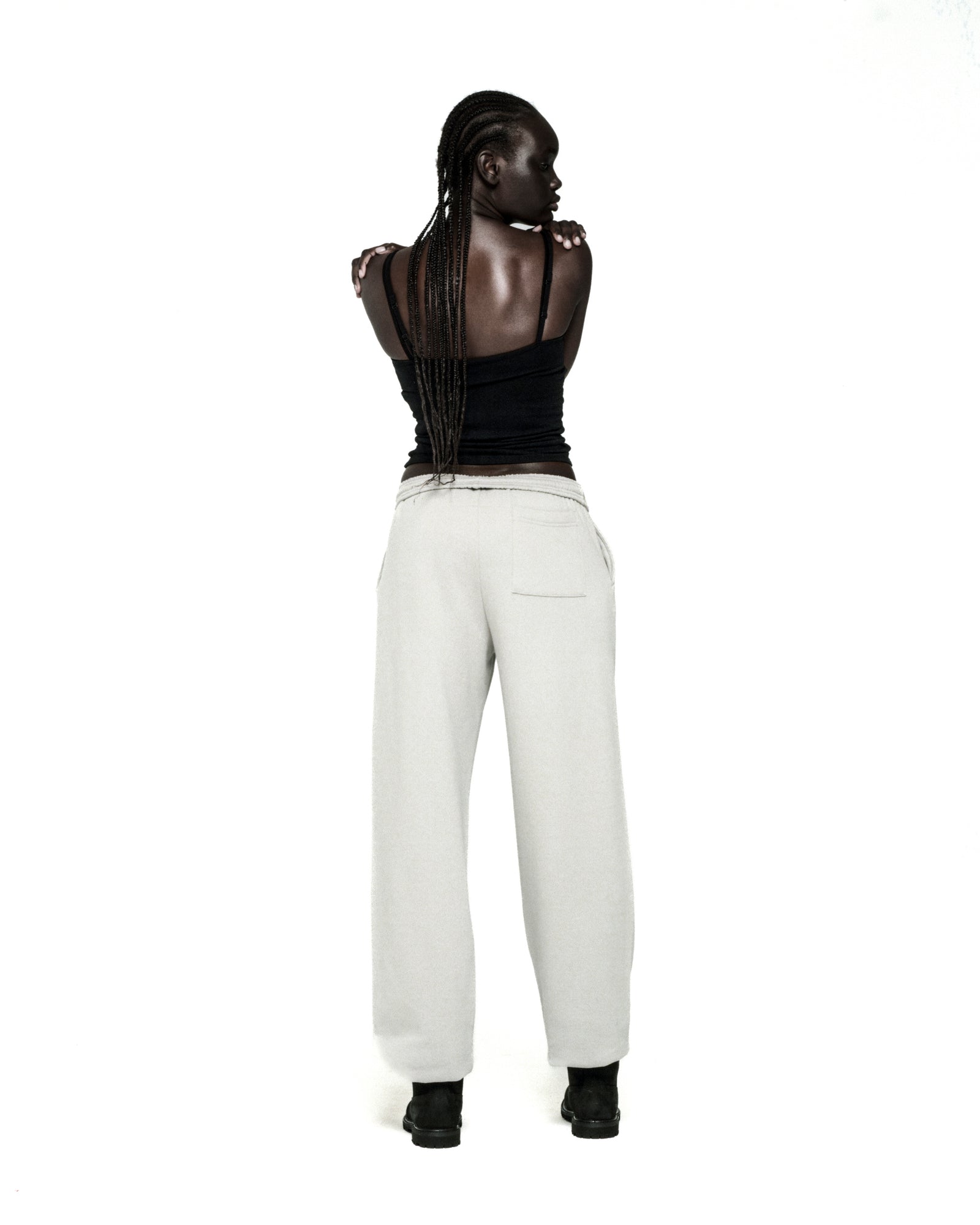 Light grey cotton fleece sweatpants with elasticized waistband and cuffs, seen from behind.