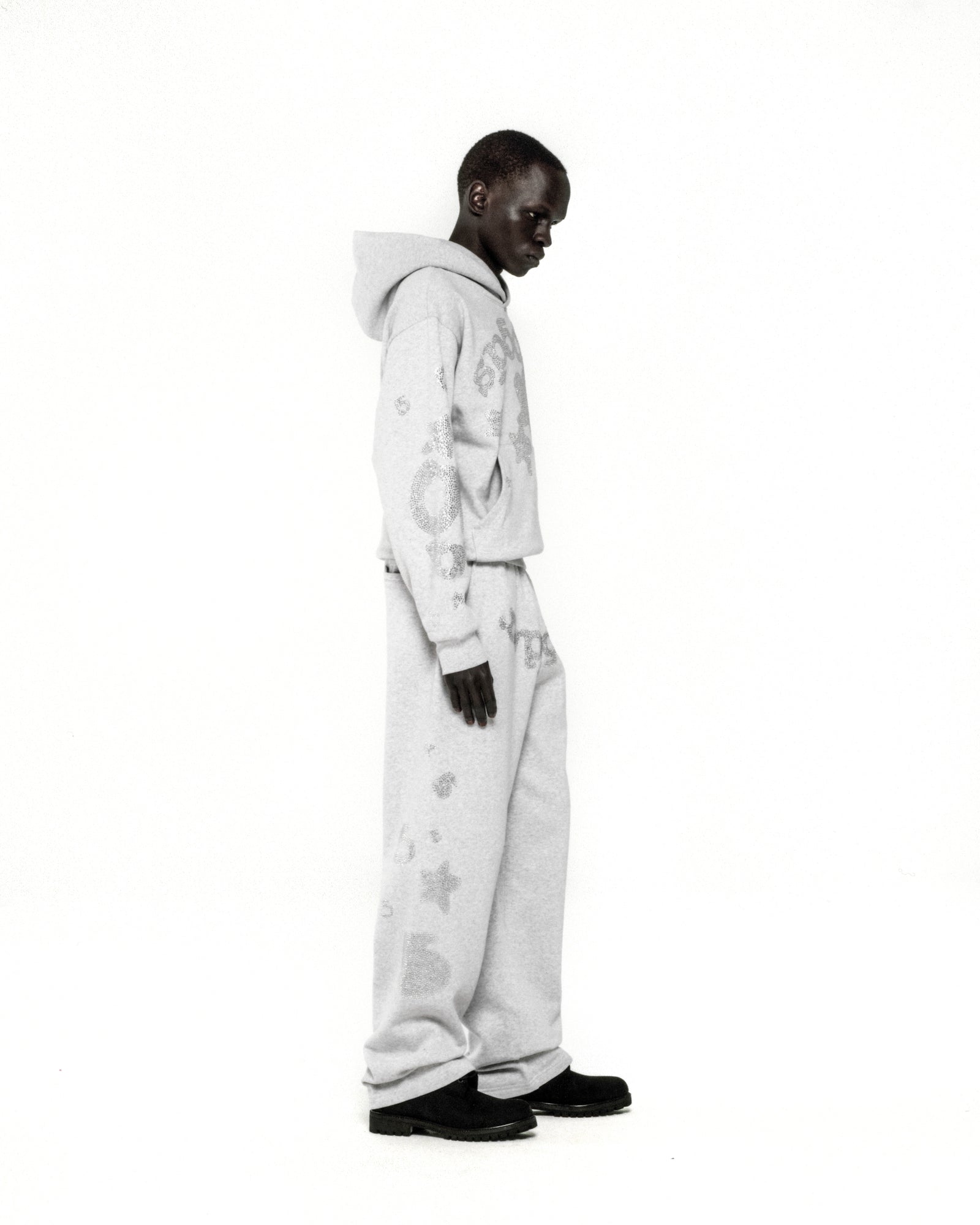 Light grey 100% cotton fleece hoodie and sweatpants with rhinestone 'SP5DER' and star designs.