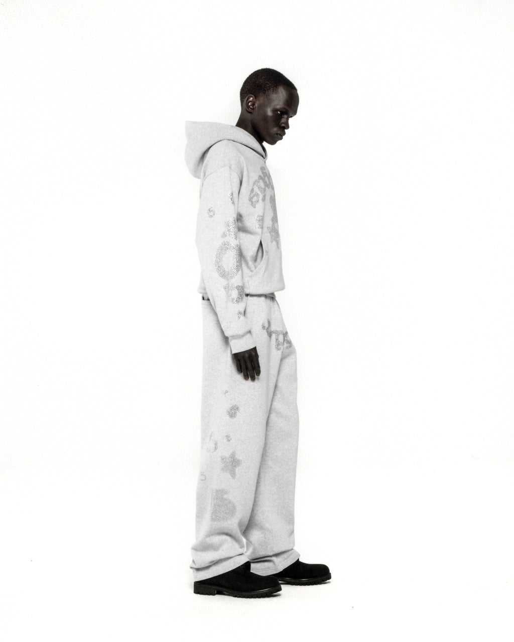 Light grey 100% cotton fleece hoodie and sweatpants with rhinestone 'SP5DER' and star designs.