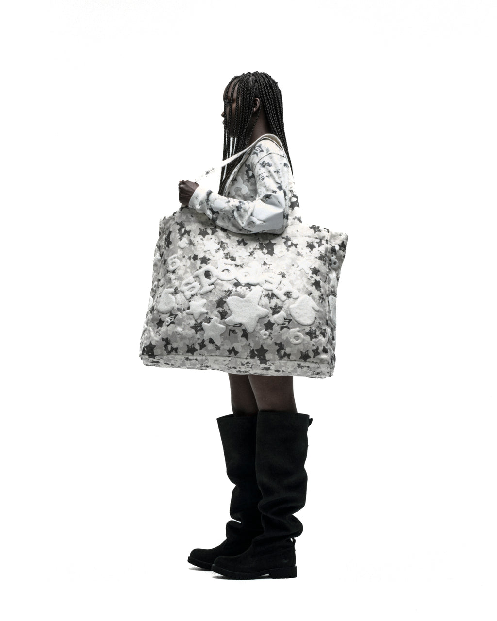 Model carrying a large white star camo twill tote bag with a beluga graphic.