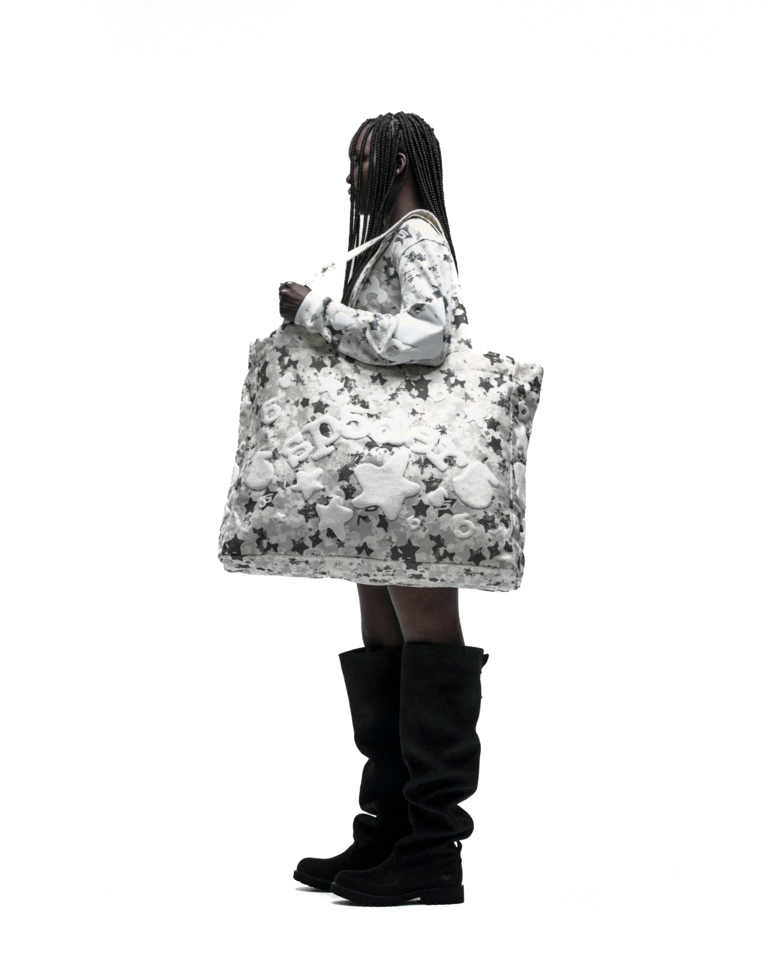 Model carrying a large white star camo twill tote bag with a beluga graphic.