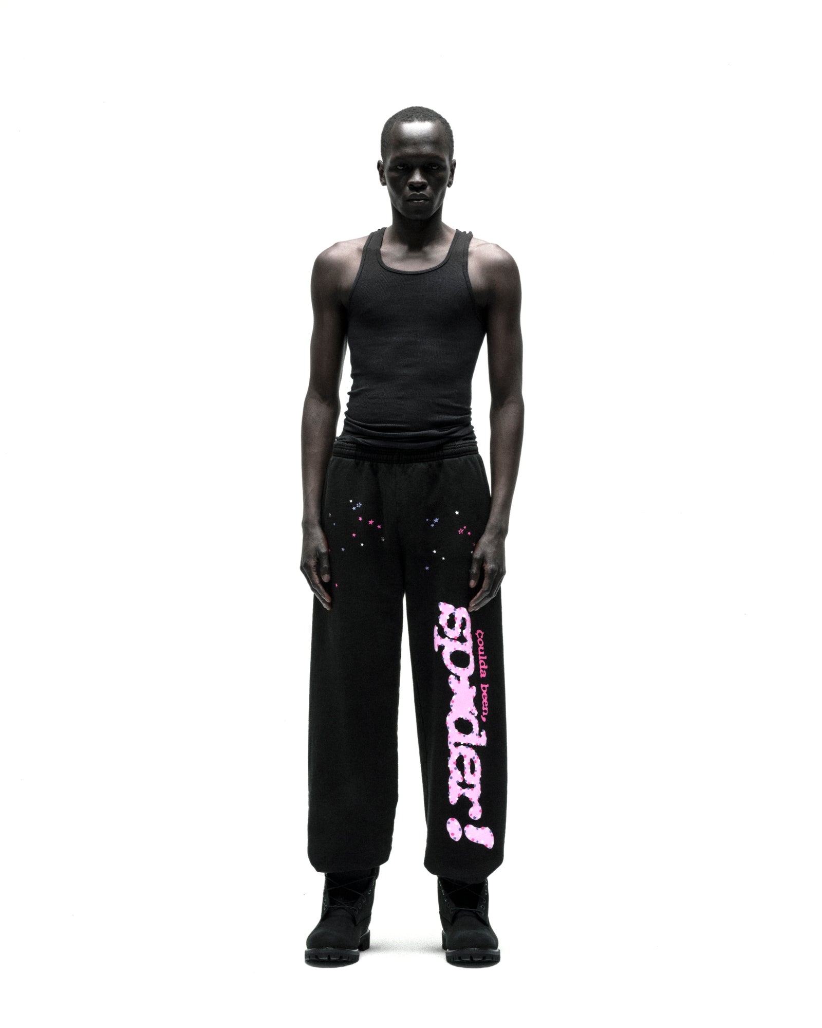 Black CB PUNK V2 sweatpants with pink "sp5der" text and scattered stars, worn by a model.