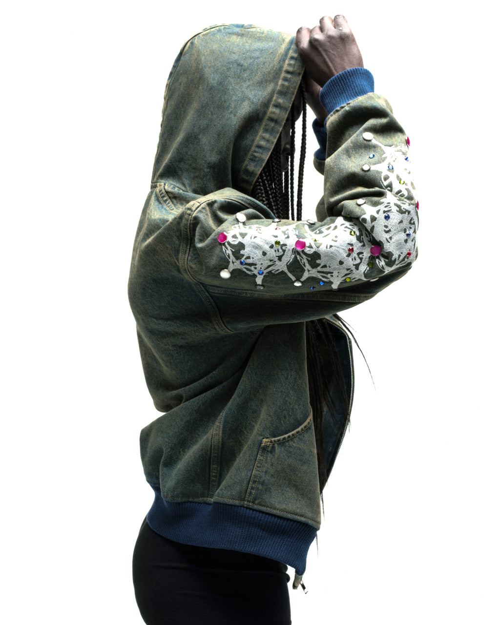 Faded denim hooded jacket with white web print and colorful rhinestone embellishments on sleeves.
