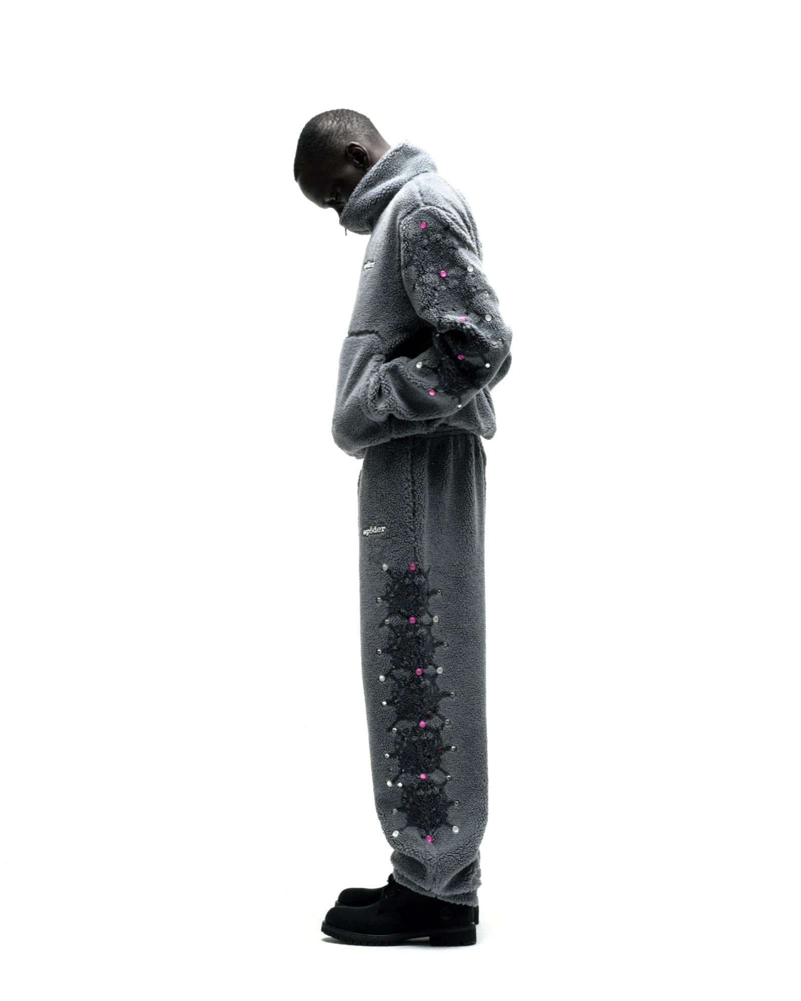 Gray sherpa fleece zip-up jacket and sweatpants with black web print and pink rhinestone embellishments.