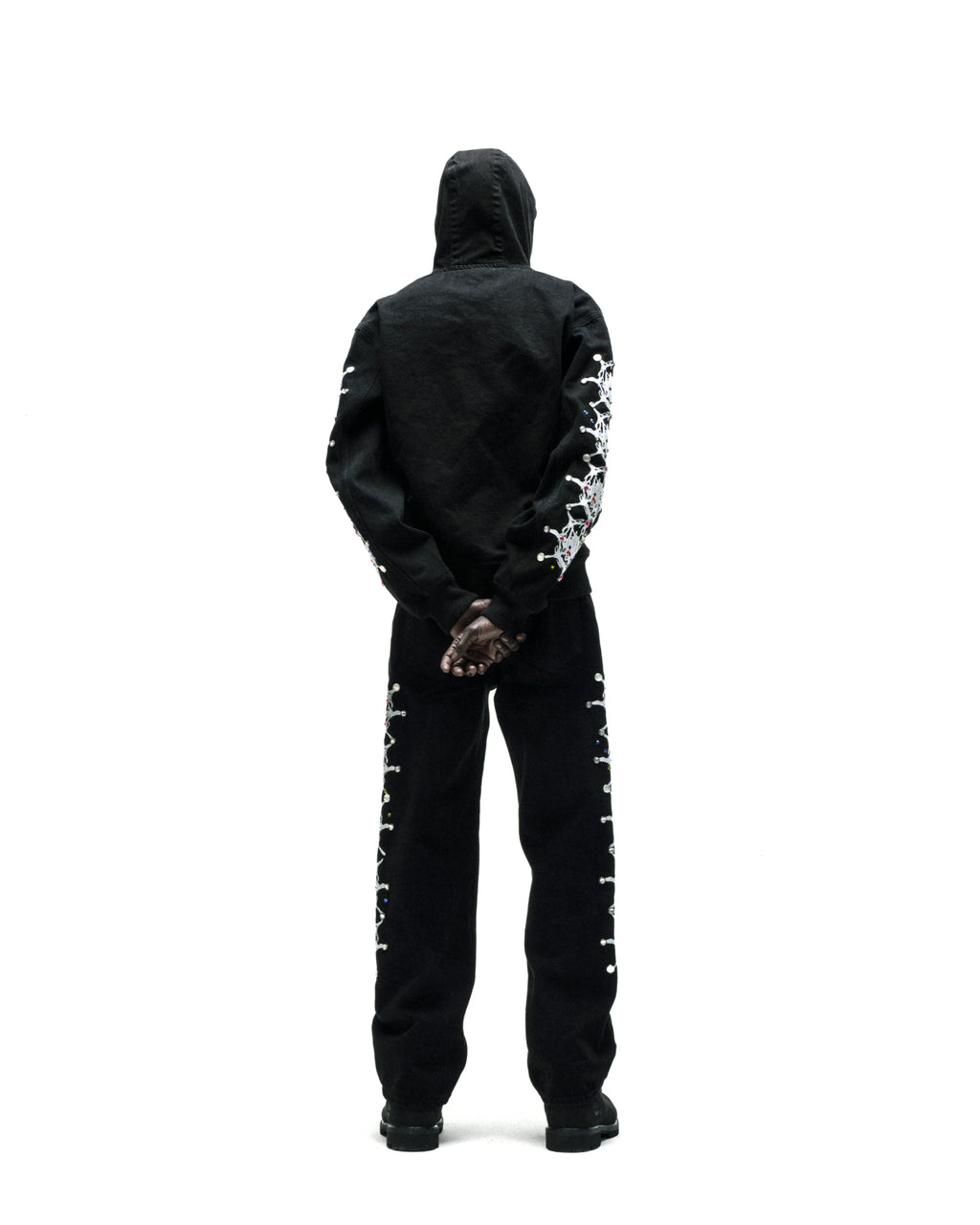 Black cotton canvas hooded jacket with web print and rhinestone sleeves, paired with matching pants.