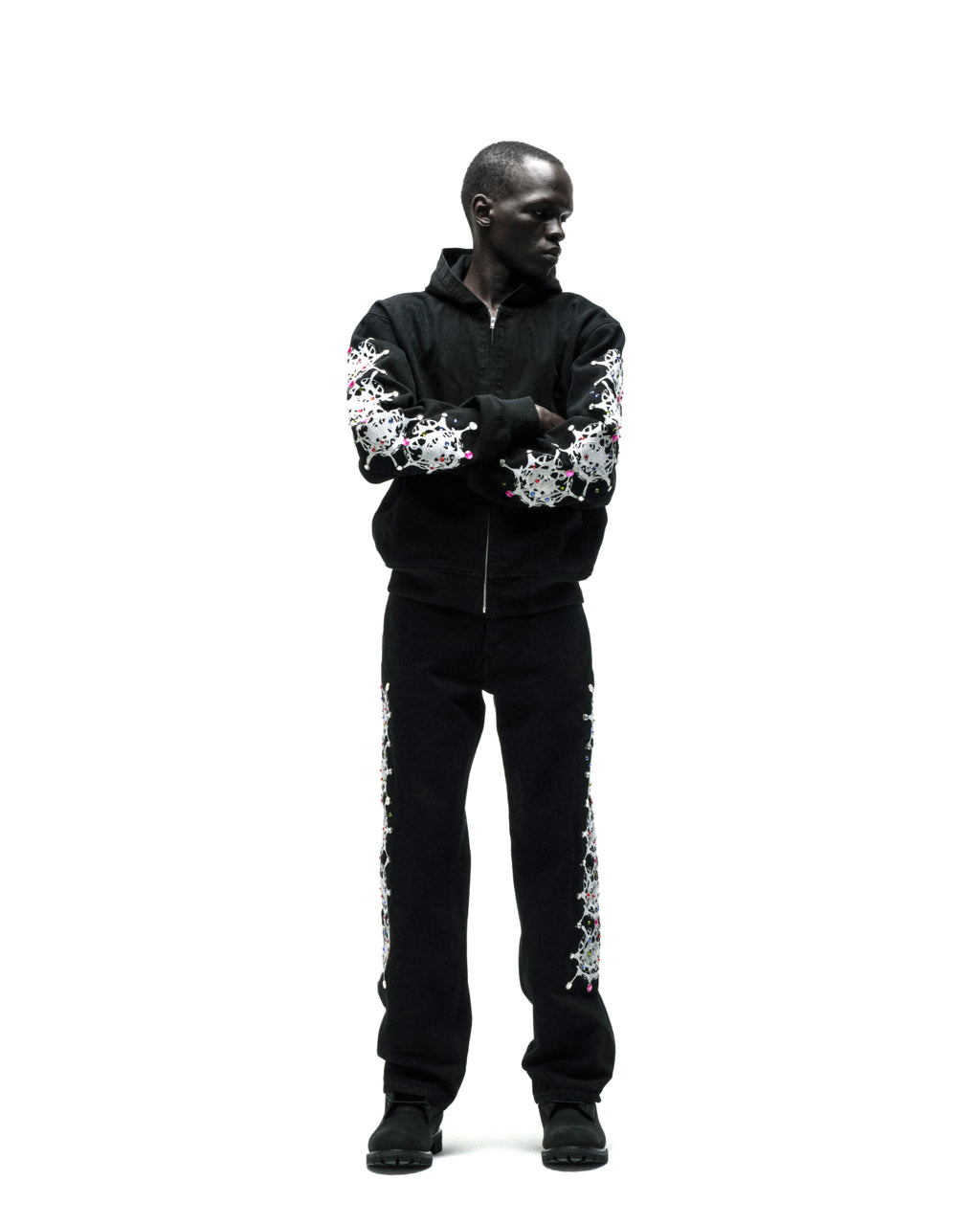 Black cotton canvas hooded jacket with web print and rhinestone sleeves.
