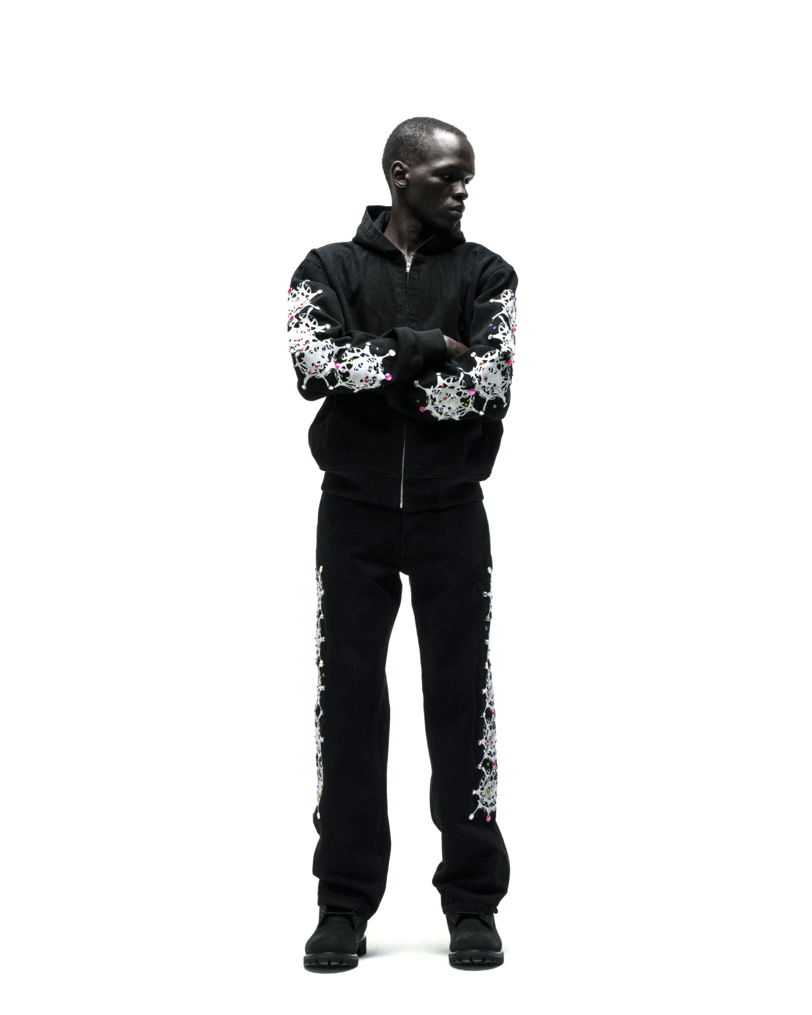 Black cotton canvas hooded jacket with web print and rhinestone sleeves.