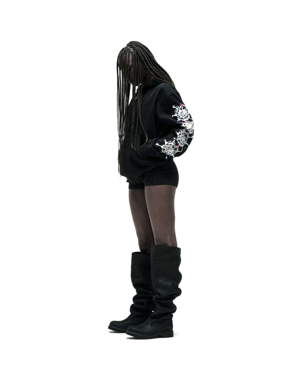 Black cotton canvas hooded jacket with web print and rhinestone sleeves, worn by a person with braids.