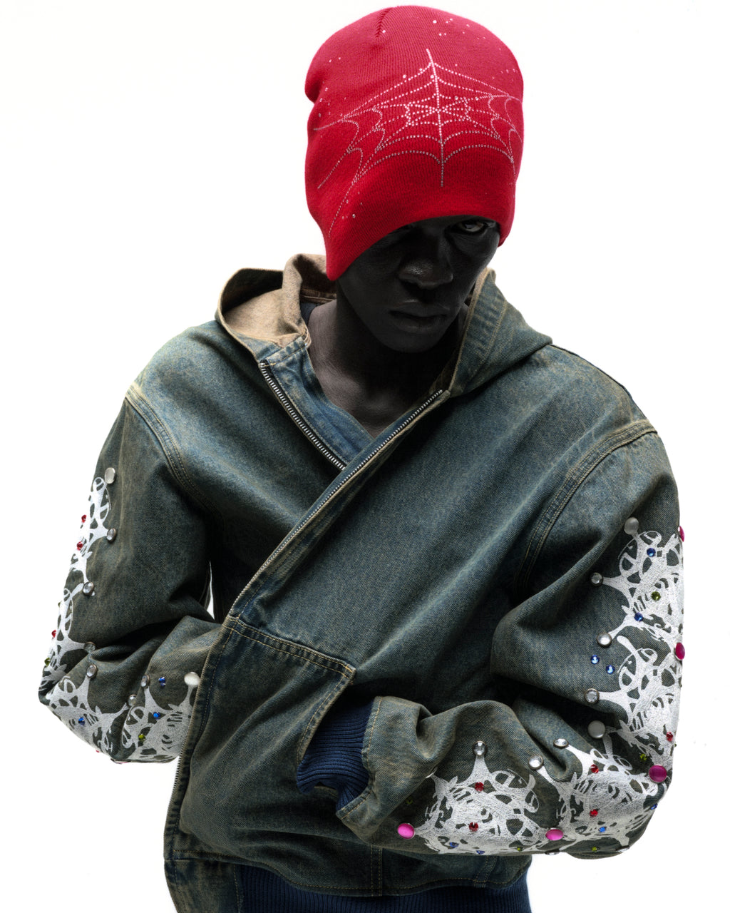Faded denim hooded jacket with web print and rhinestone embellishments on sleeves, zip closure, patch pockets.