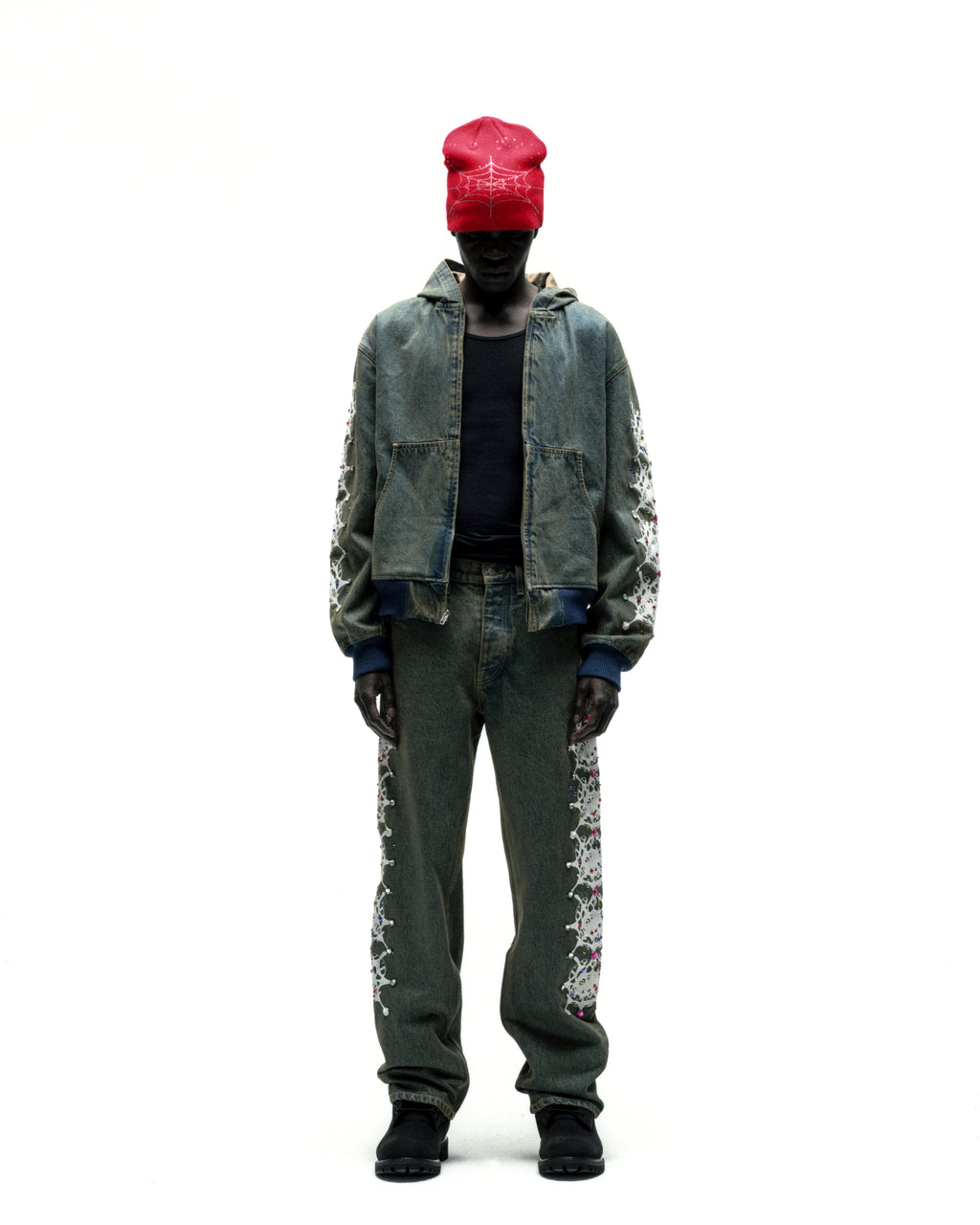 Faded denim jacket with web print, rhinestone sleeves, zip closure, patch pockets, and rib-knit trim.