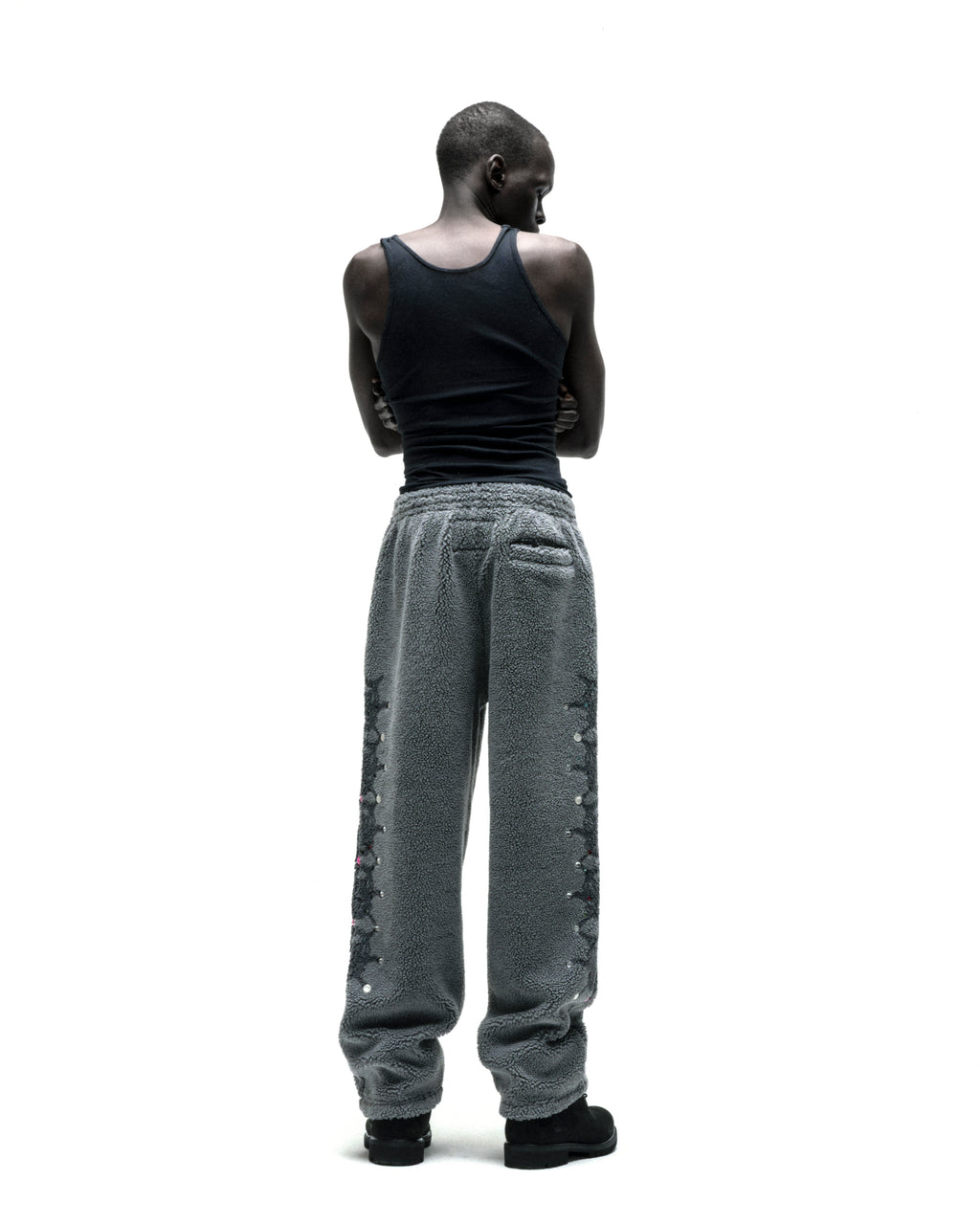 Gray sherpa fleece pants with web print, rhinestone embellishments, and a rubberized logo patch.
