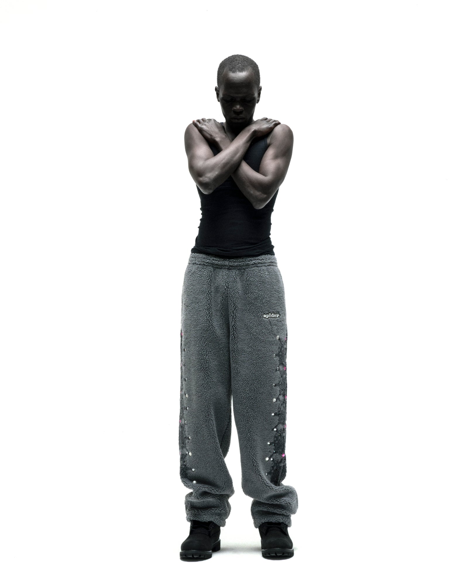 Gray sherpa fleece pants with rubberized logo, web print, and rhinestone embellishments.