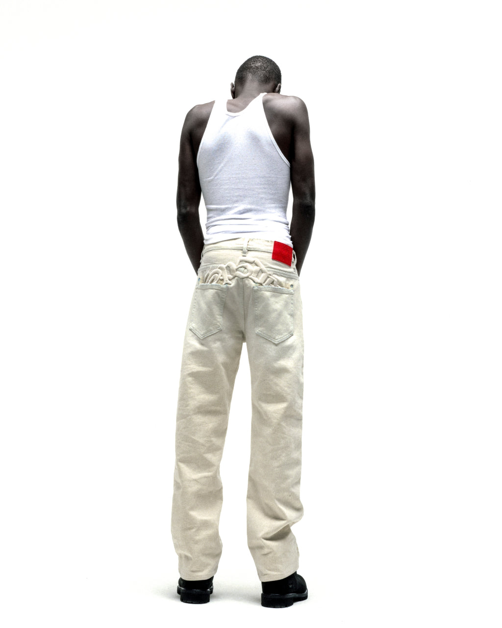 OXY JEAN 13oz off-white denim pants with embroidered text, red leather patch, and straight leg fit.