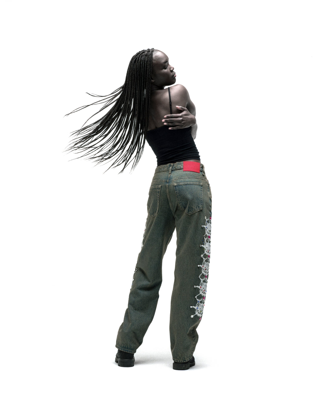 Vintage wash 13oz denim pants with web print and rhinestone embellishments, branded leather patch.