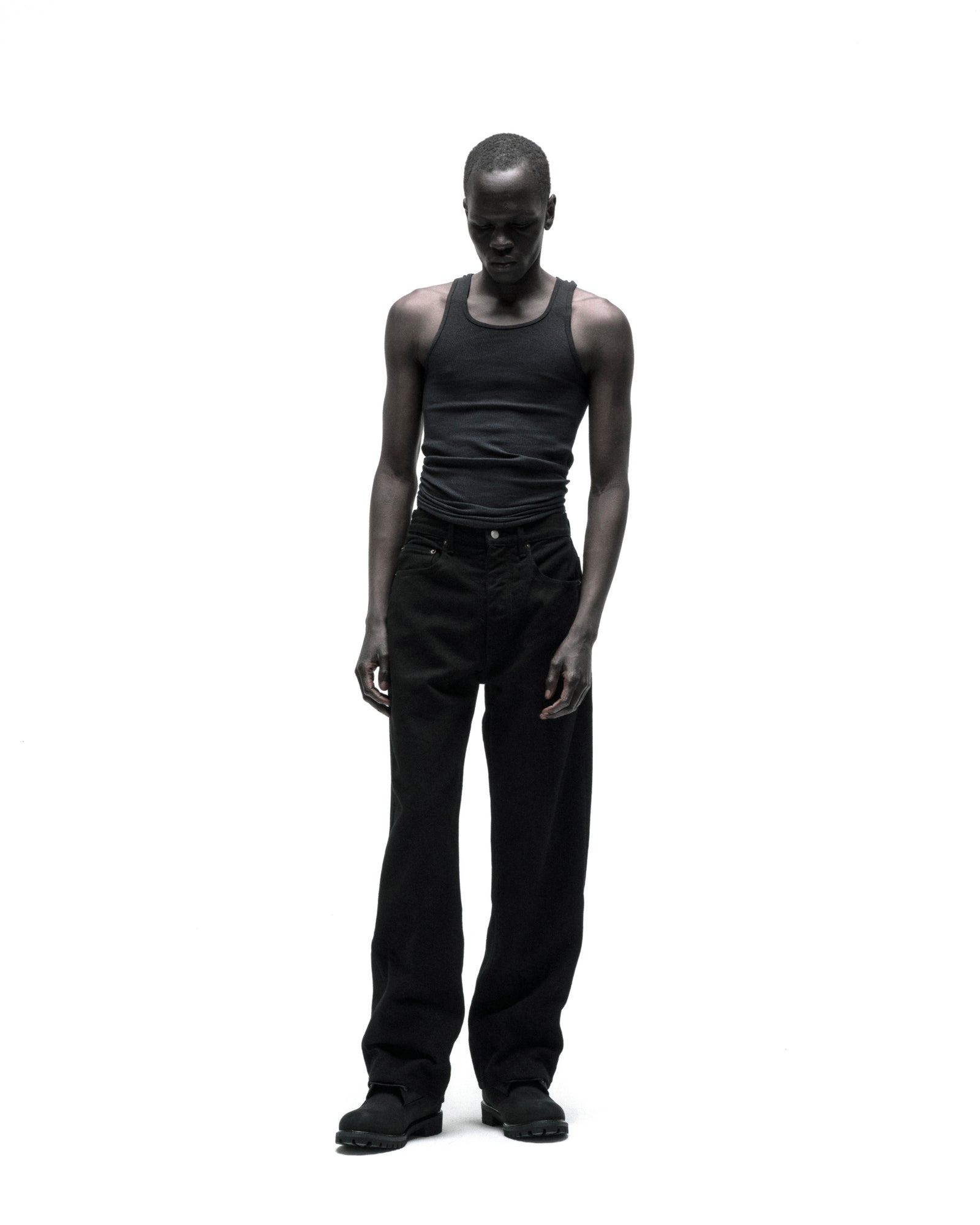 Model wearing OXY JEAN, black 13oz denim straight leg pants with branded hardware.