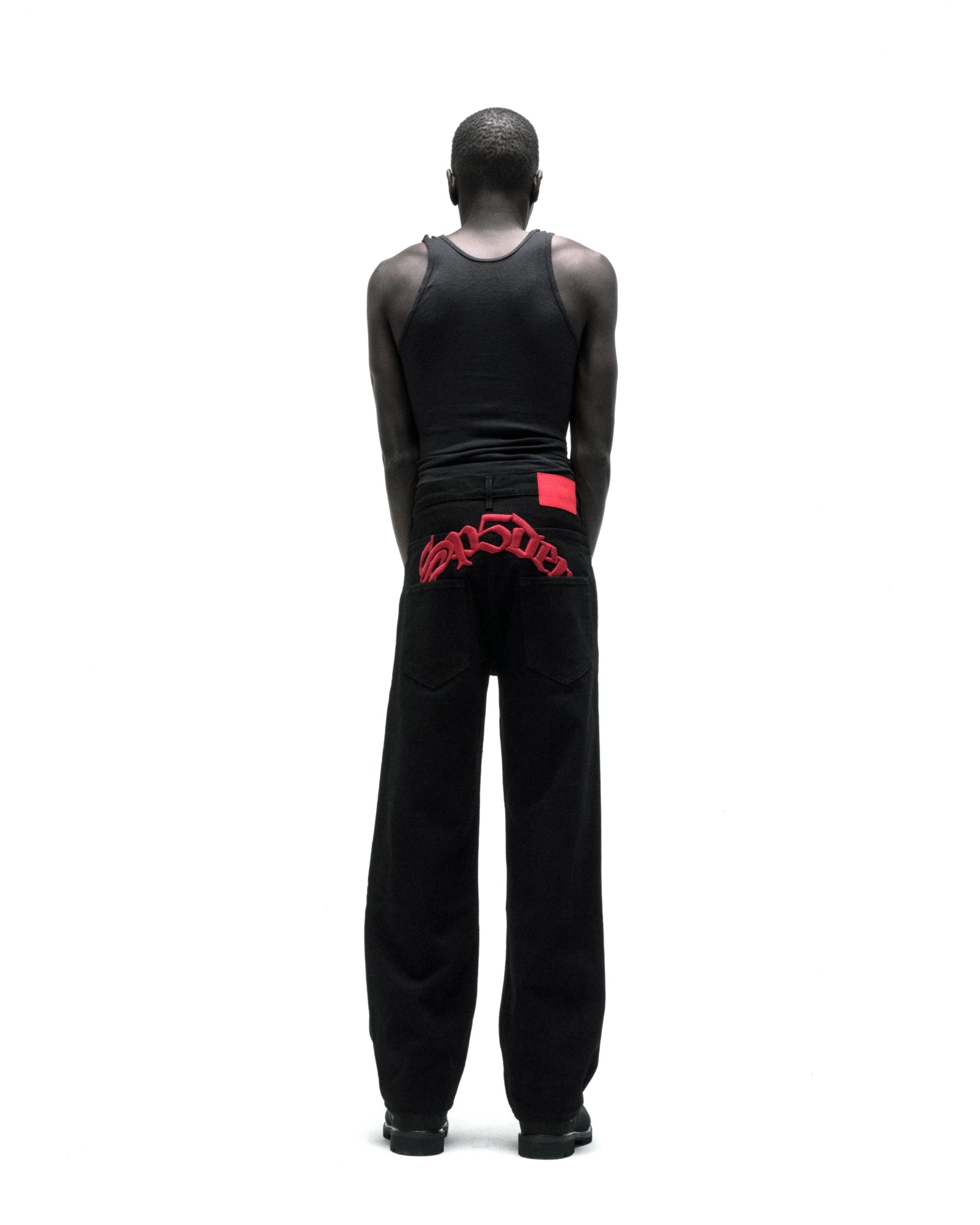 Black 13oz denim OXY JEAN with red embroidered text above back pockets and a red leather back patch.