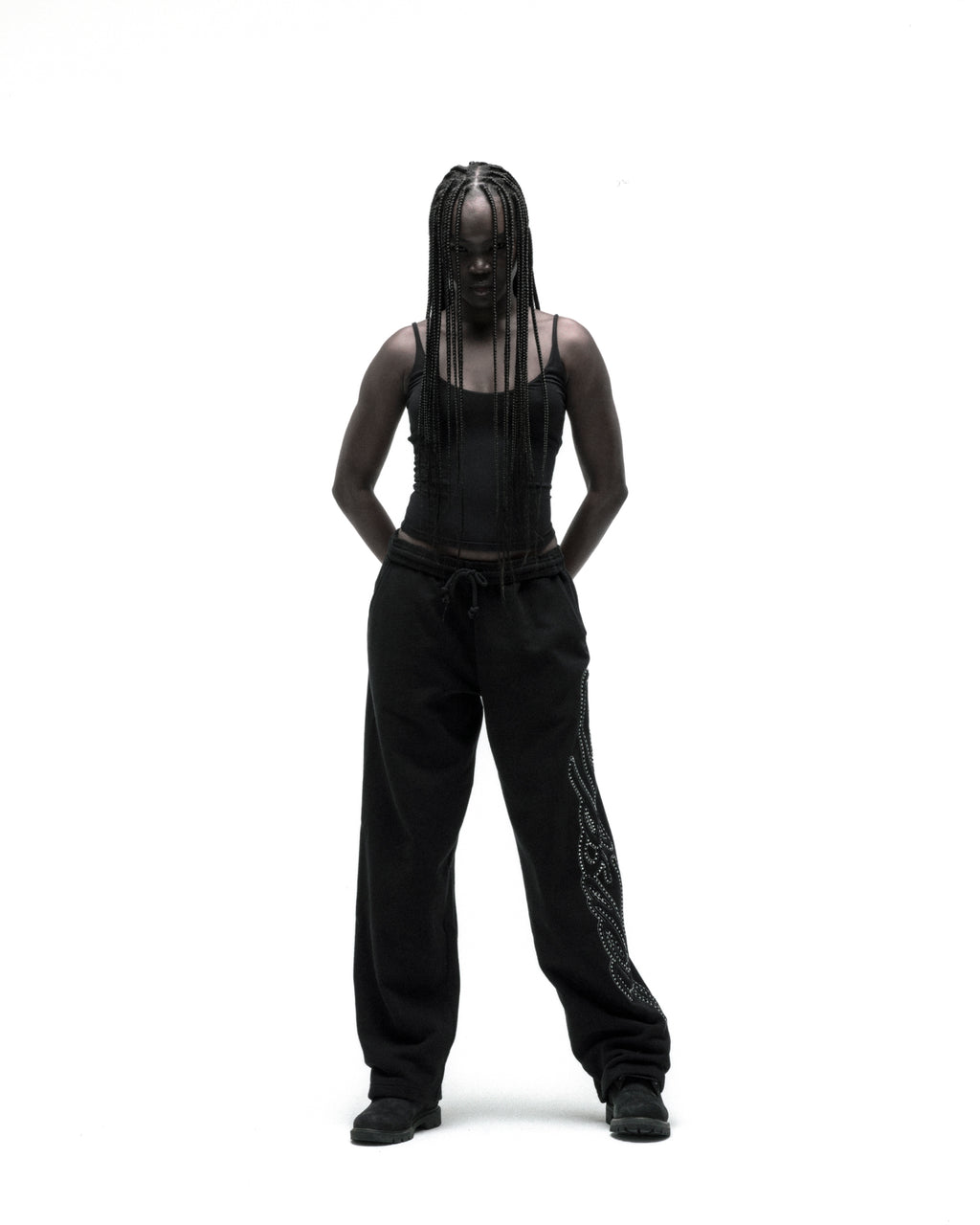 Black cotton fleece wide-leg sweatpants with rhinestone script down the leg, worn by a model.