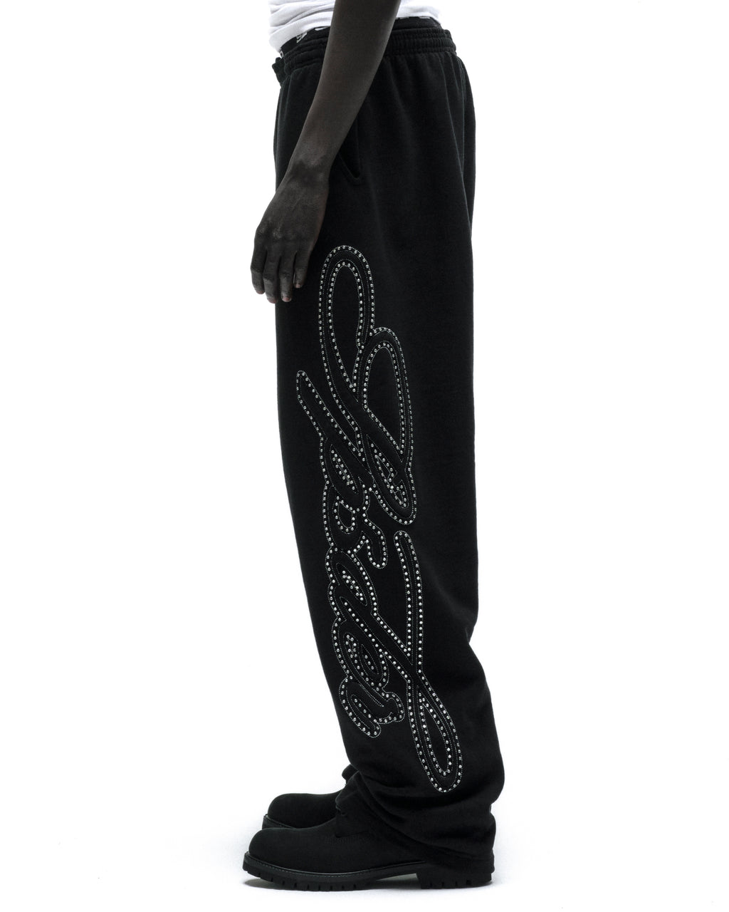 Black 100% cotton fleece wide-leg sweatpants with a rhinestone script design down the leg.