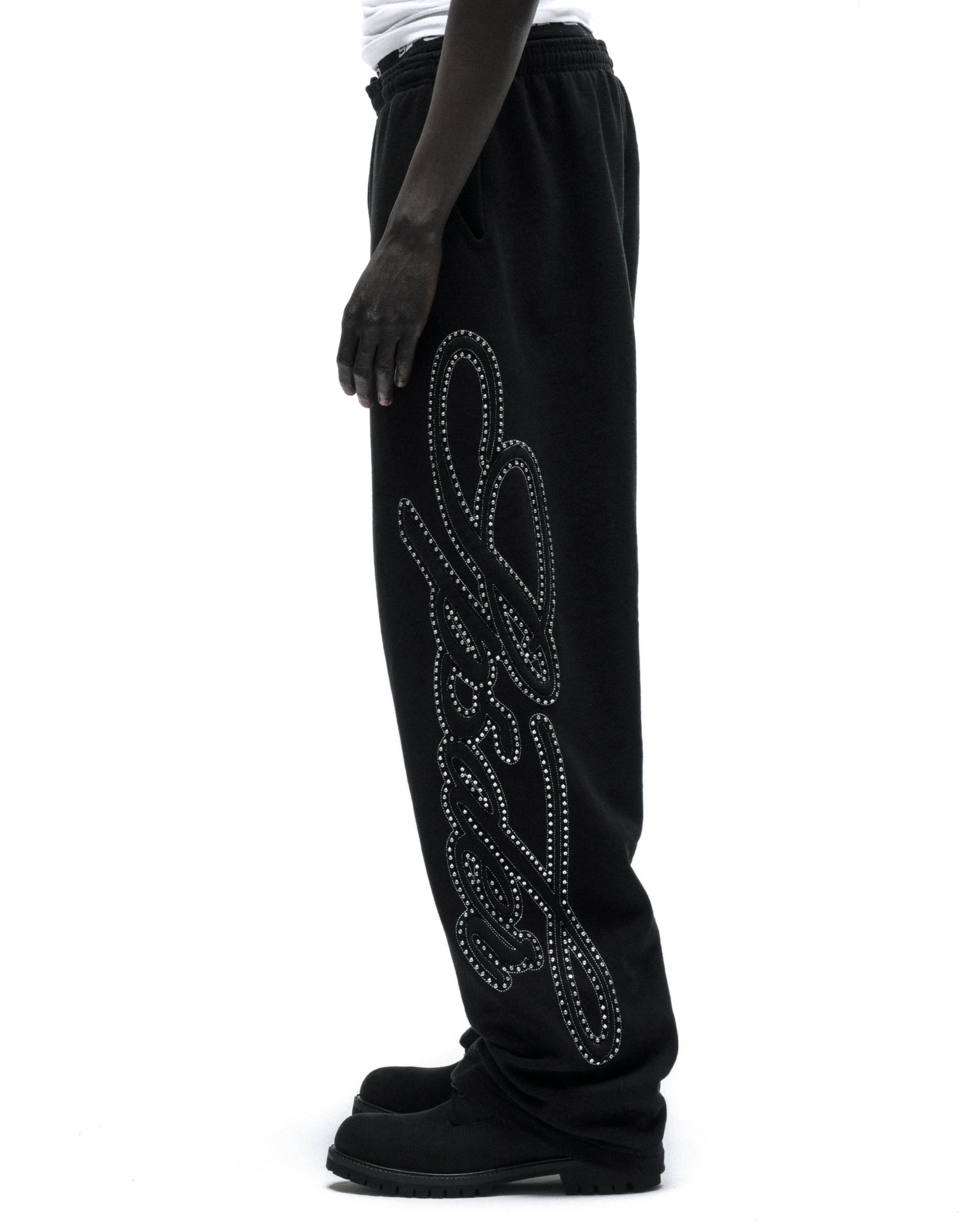 Black 100% cotton fleece wide-leg sweatpants with a rhinestone script design down the leg.