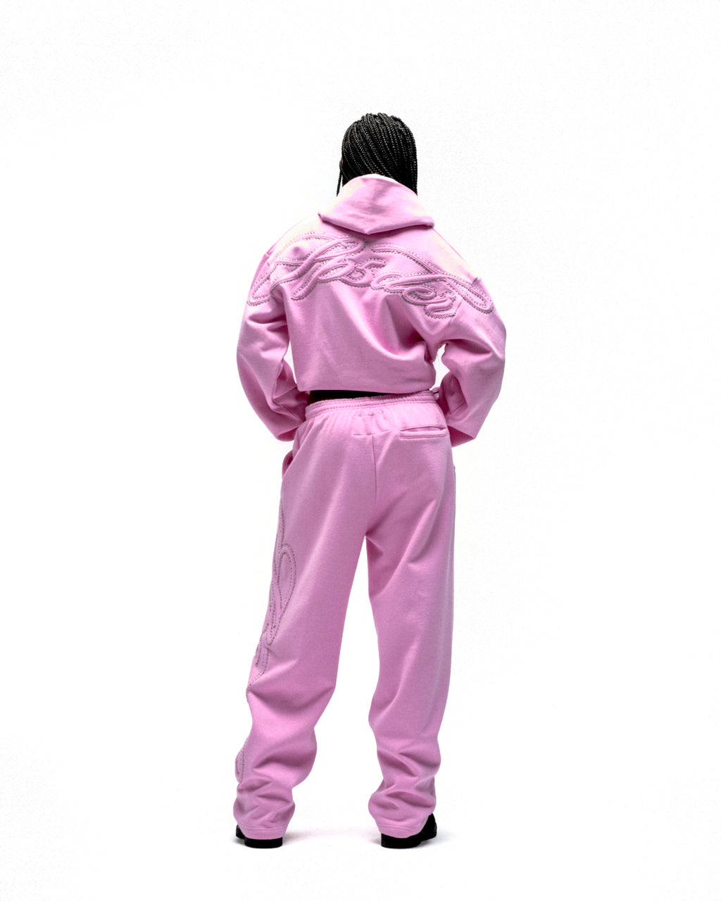 Pink rhinestone script zip hoodie and sweatpants set on a model, back view.
