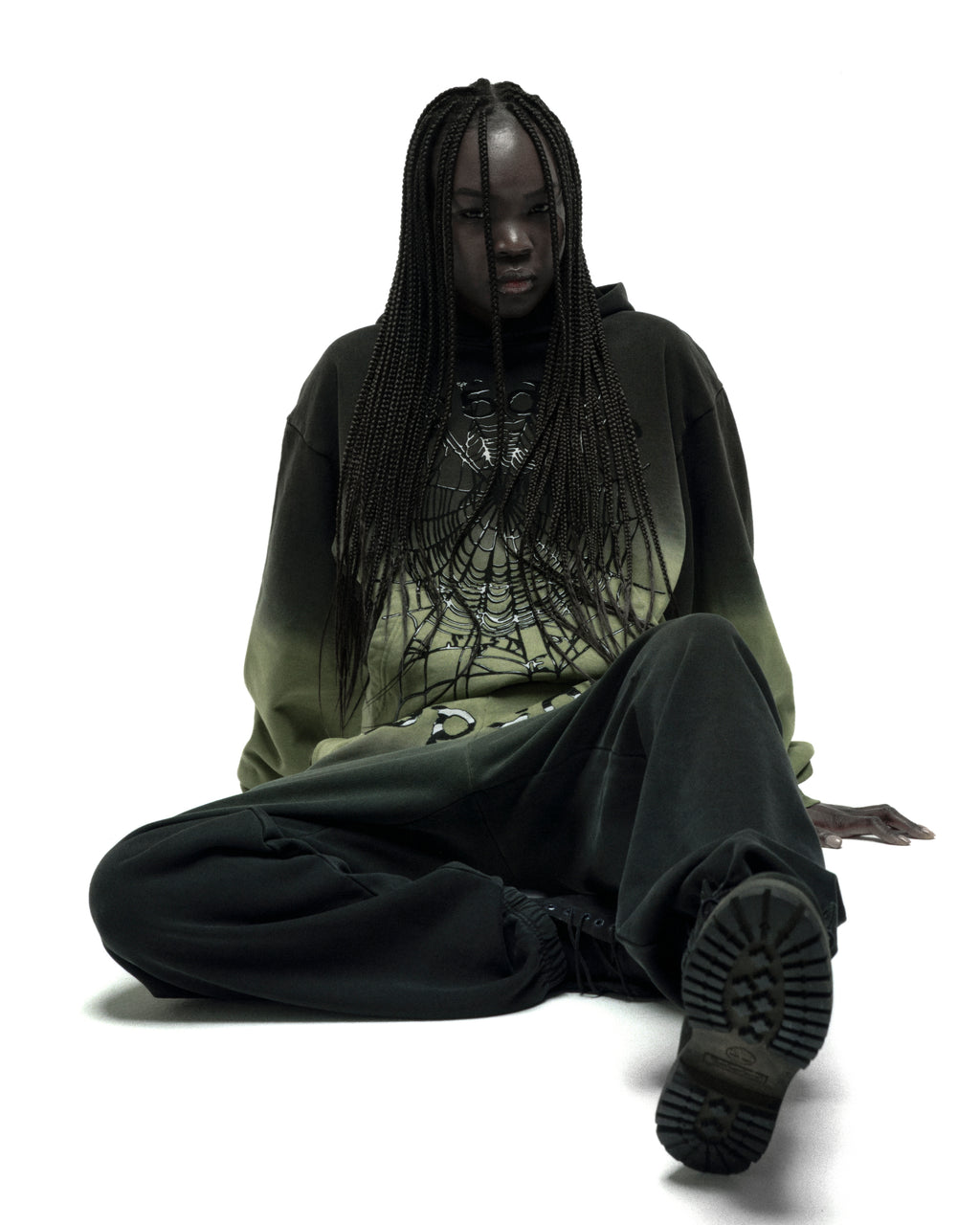 Model wearing an OG WEB OMBRE HOODIE, 13oz cotton fleece with puff print spiderweb design.