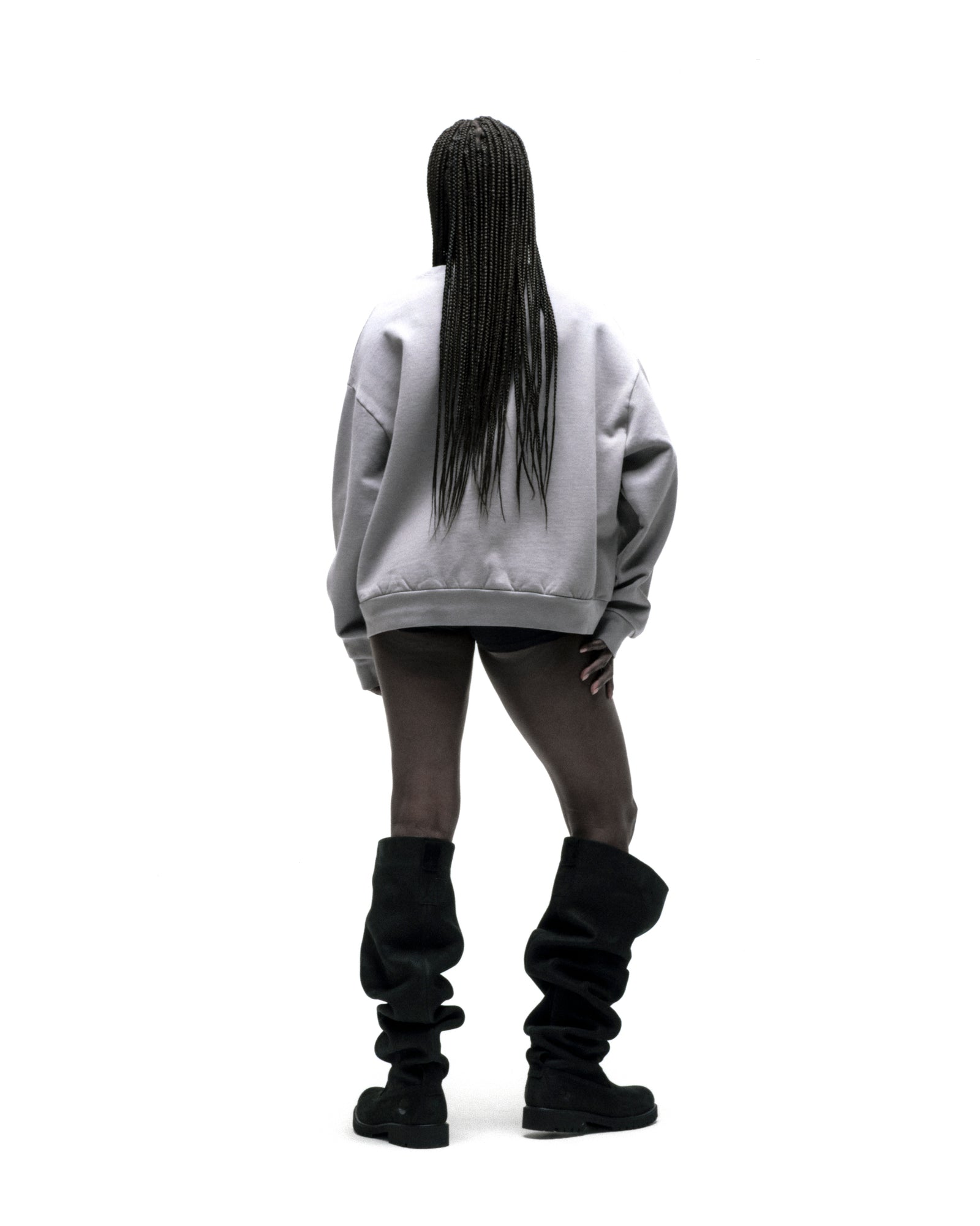 Back view of a person wearing an oversized light grey SP5DER CUNTRY CREWNECK sweatshirt.