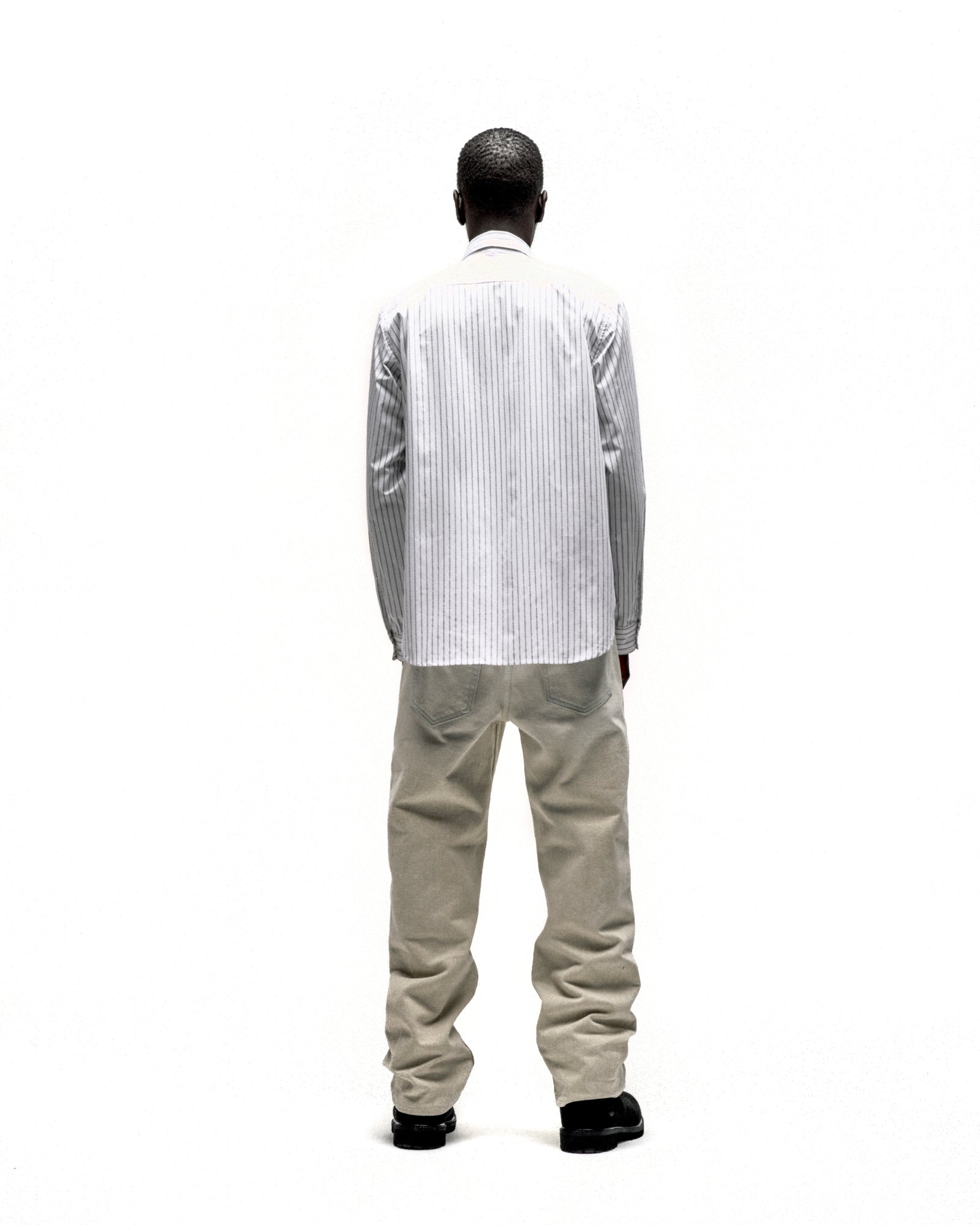 Man from behind wearing a white 5-pinstripe woven cotton oxford button-down shirt with a spread collar.